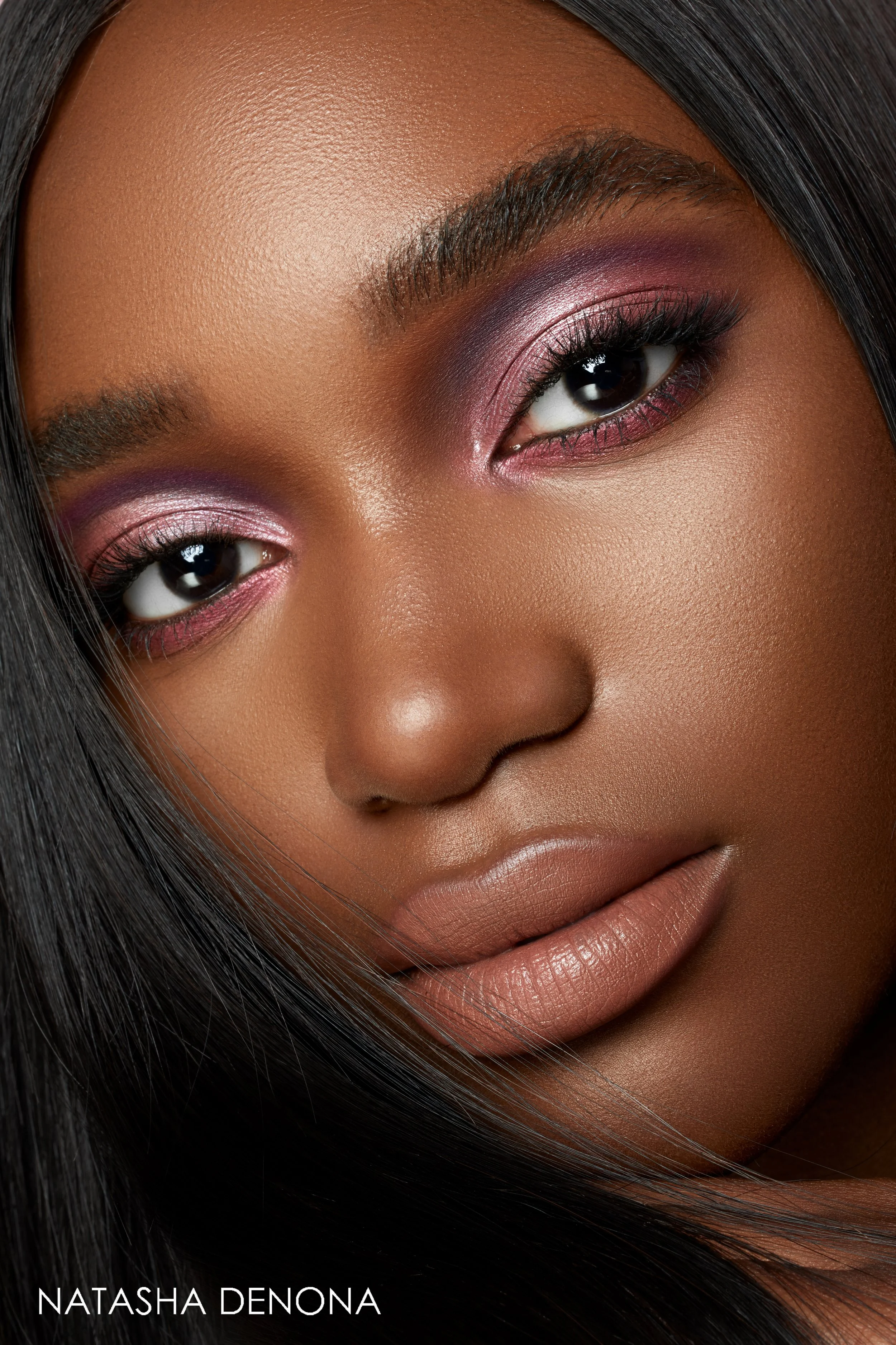 Nahaufnahme eines Gesichts einer Frau mit dunklem Haartyp, makeup, und intensiven Blick.