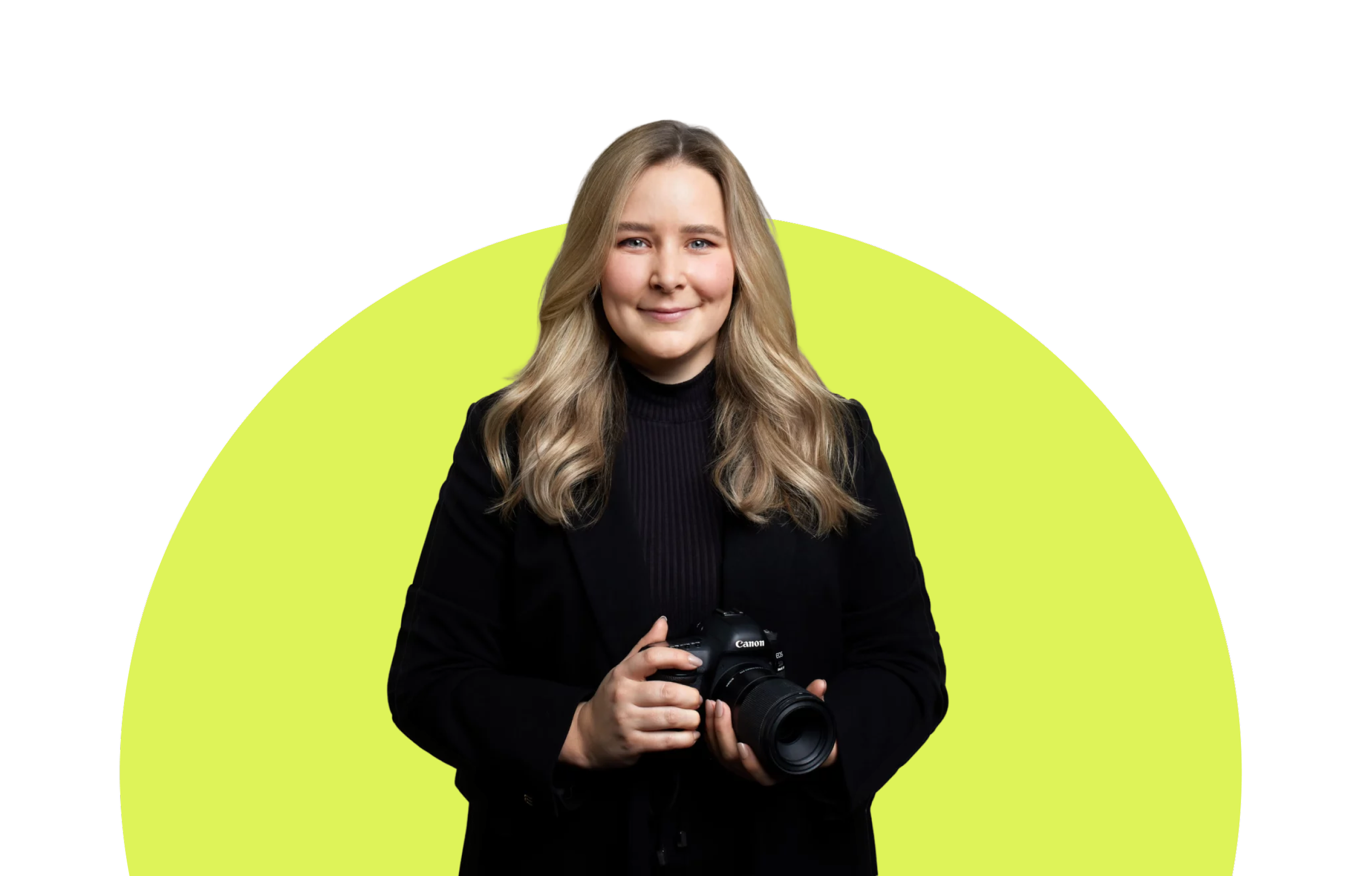 Eine Frau mit langen, blonden Haaren hält eine Canon Kamera und lächelt vor einem neon-grünen Hintergrund.