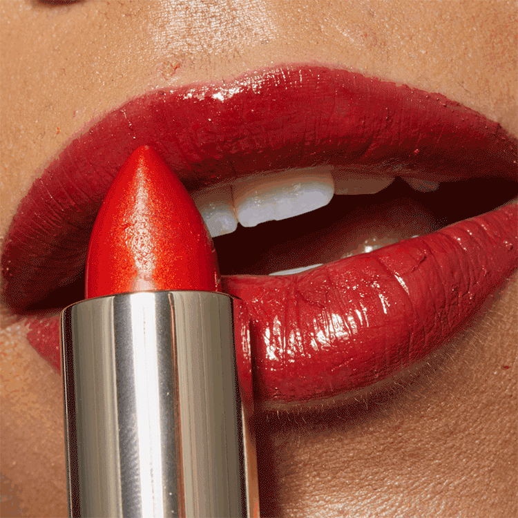 Nahaufnahme von roten Lippen, die ein rotes Lippenstift tragen, und einer Lipgloss, der auf den Lippen aufgetragen wird.