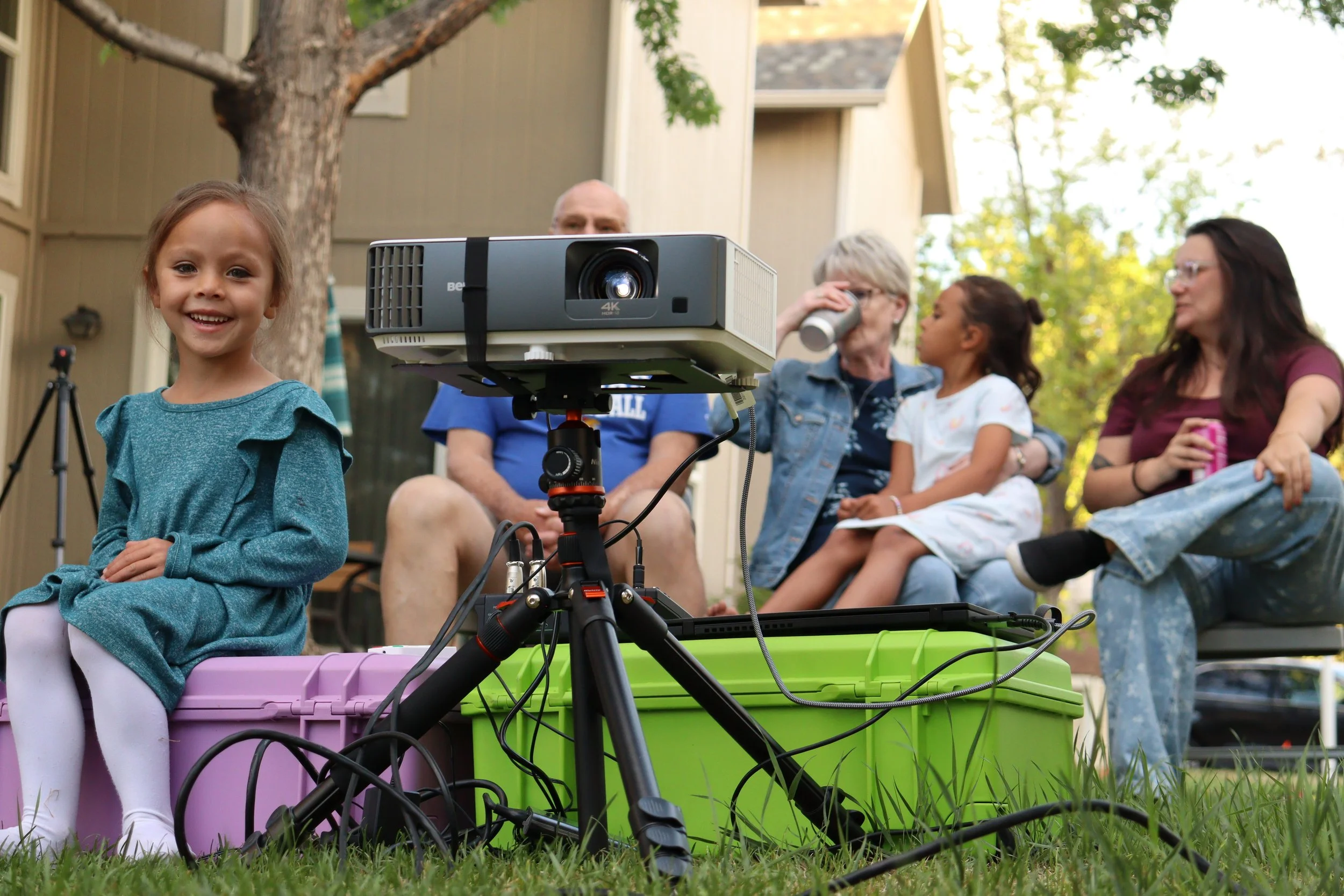 Family Enjoying Backyard Cinema Experience with Projector, Audio and Portable Screen