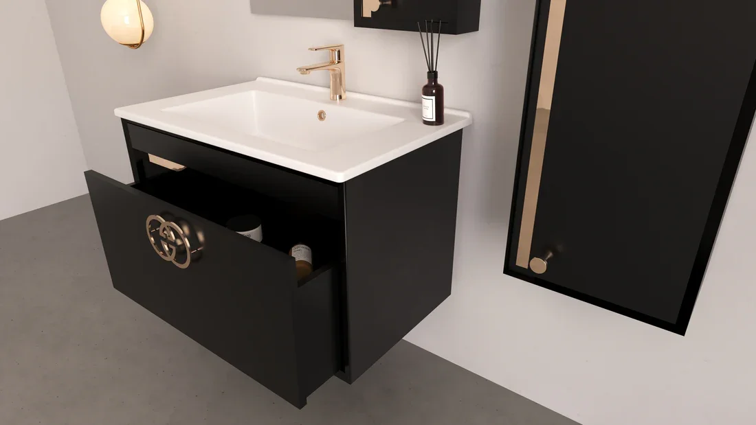 Modern vanity with a black cabinet, a white sink, and a gold faucet, with a bottle and reed diffuser on top, a large black mirror leaning against the wall, and a wall-mounted black cabinet.