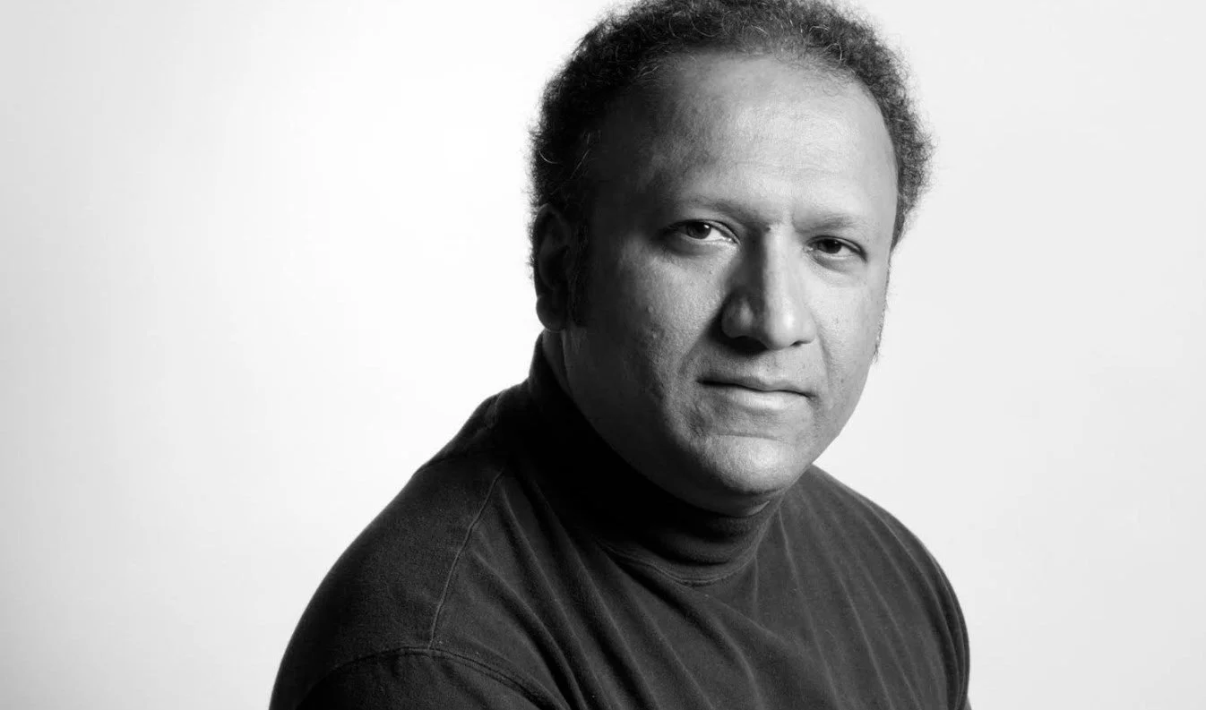 Retrato en blanco y negro de S. T. Joshi con cabello rizado y camisa negra, mirando hacia la cámara.