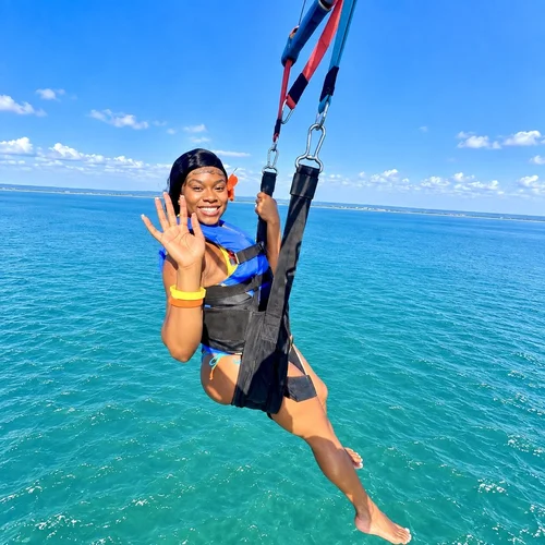 Friends parasailing together over the water