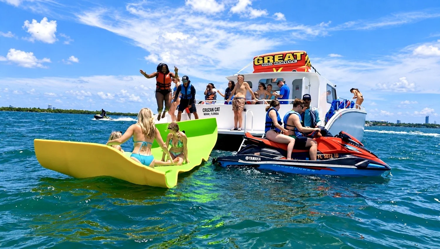 Guests on jet skis and a water mat next to the boat in Miami