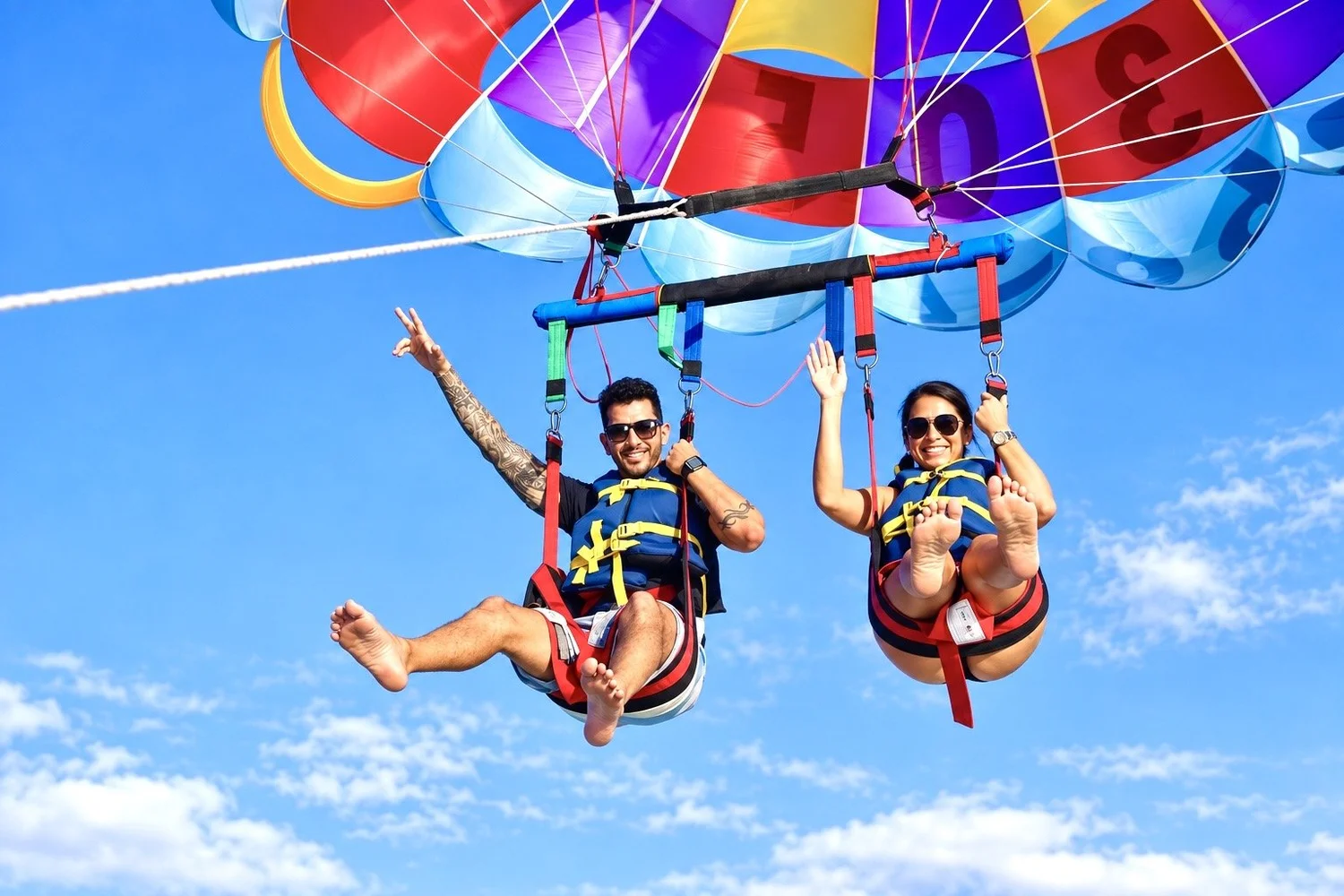Couple parasailing under a colorful canopy in Miami