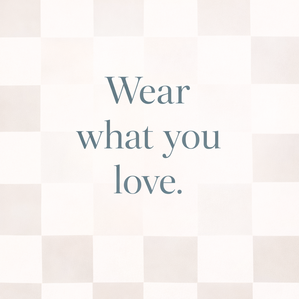 Inspirational quote that says, 'Wear what you love.' on a light, checkered background.