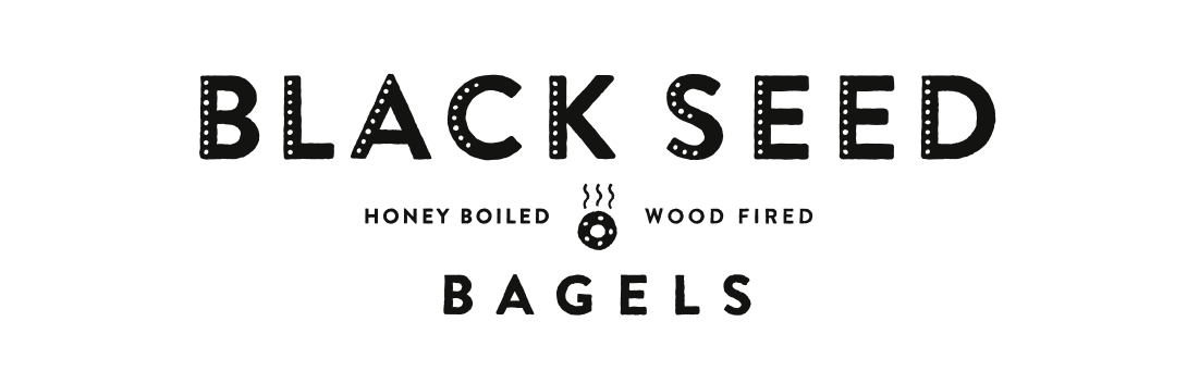 Black Seed Bagels logo with the words 'Honey Boiled' and 'Wood Fired' in small text and a steaming bagel icon in the center.