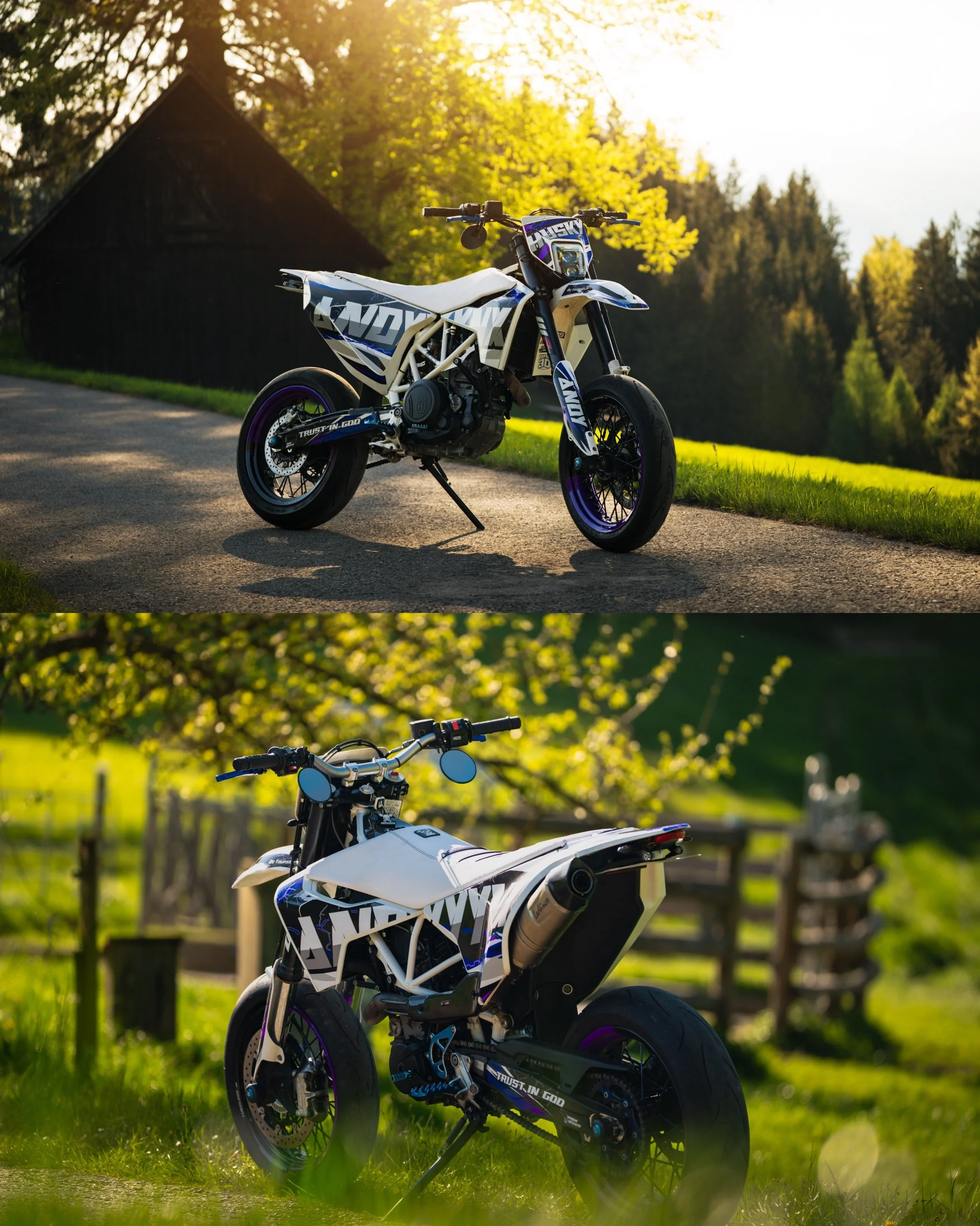 Ein offroad-Motorrad mit weißem Rahmen und blauen Akzenten steht in einer ländlichen Umgebung, im Vordergrund sind Bäume und eine Wiese, im Hintergrund eine Scheune und ein Wald, bei Sonnenuntergang.