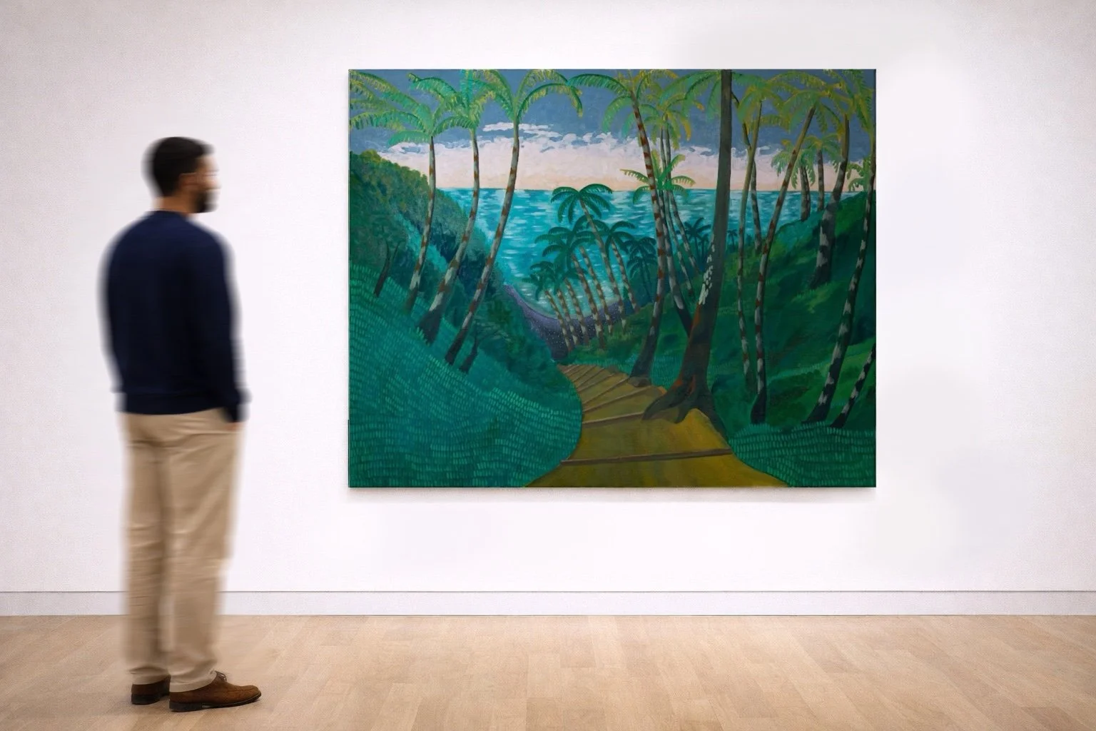 A man standing and observing a colorful landscape painting of a tropical forest with a path, trees, and a body of water in the background, displayed on a white gallery wall.