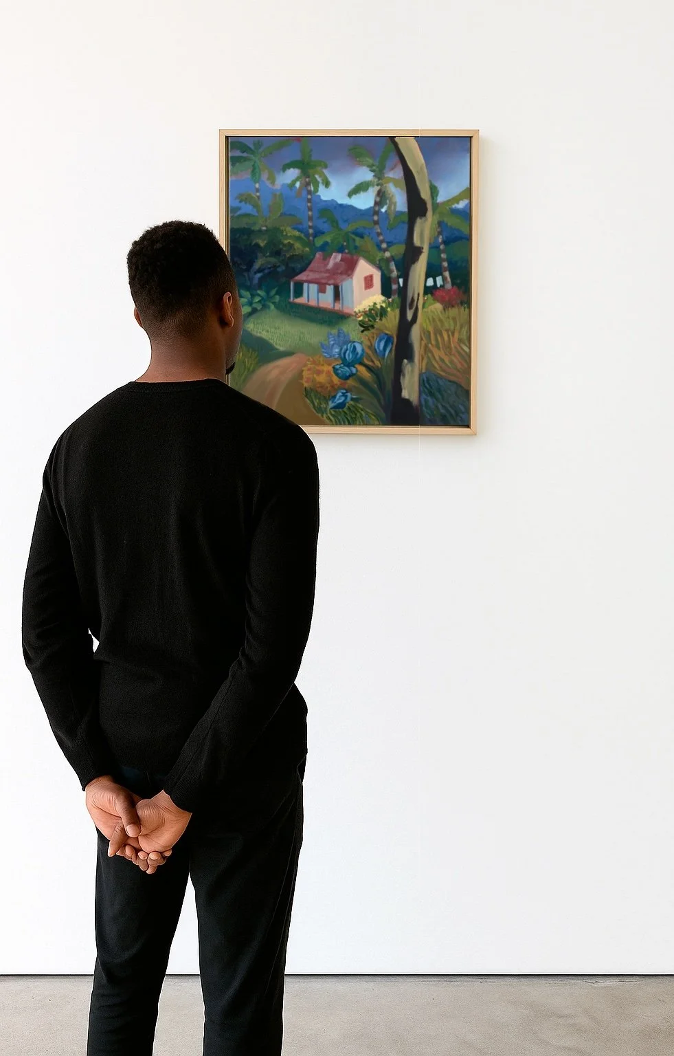 A man in a black shirt observes a colorful landscape painting of a house, trees, and mountains in an art gallery.