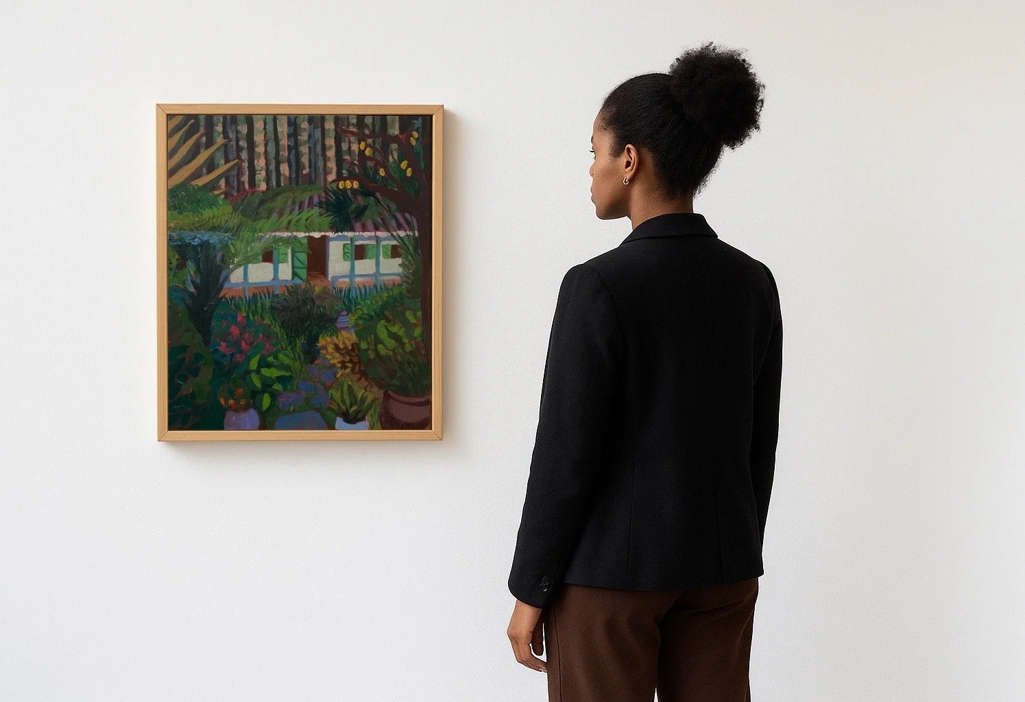 A woman with dark skin and curly hair tied in a bun is observing a colorful painting in an art gallery. The painting depicts lush greenery and plants.