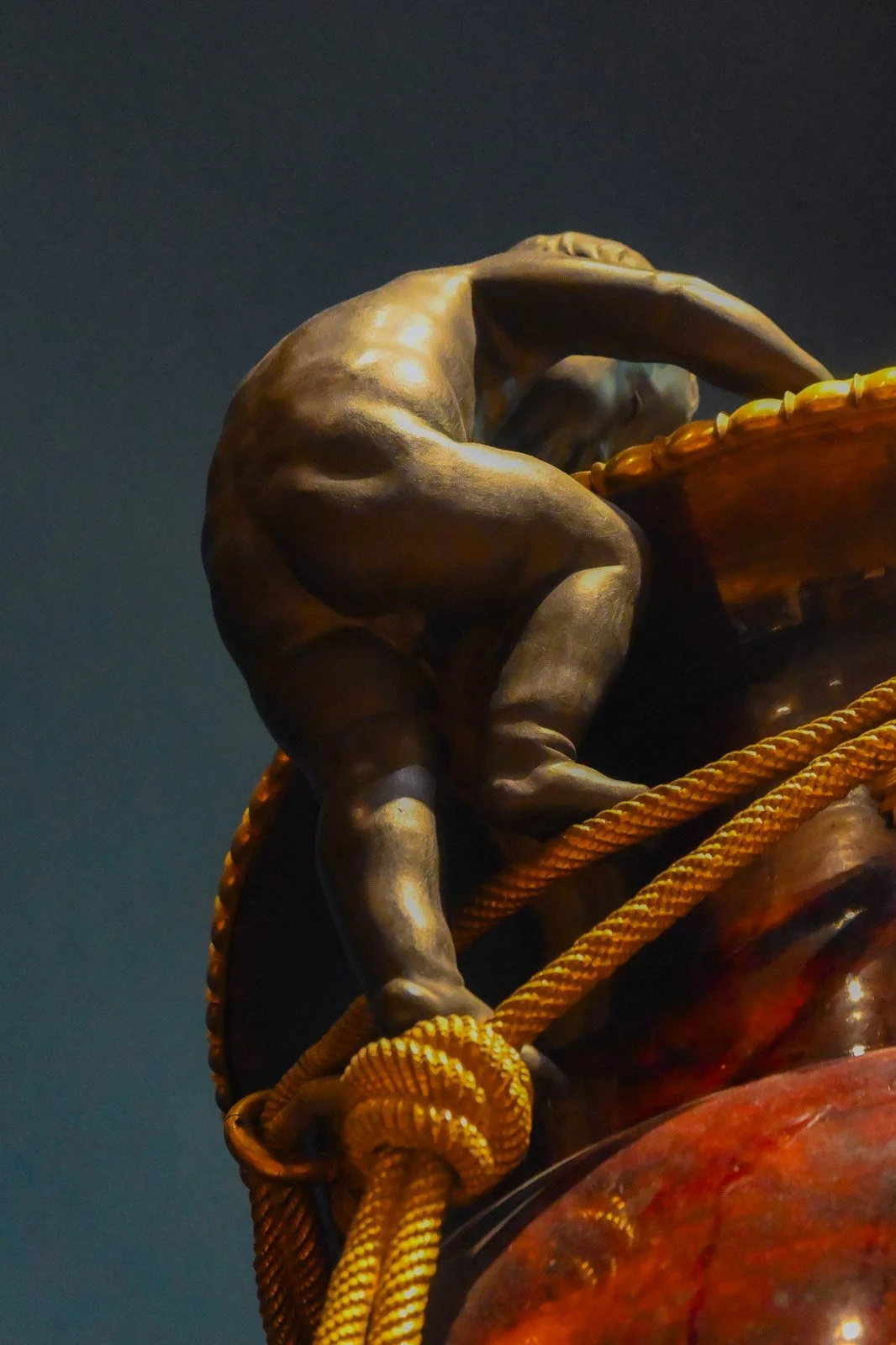 Close-up view of a gilded putto sculpture climbing on a decorative vase inside the Palace of Versailles in France.