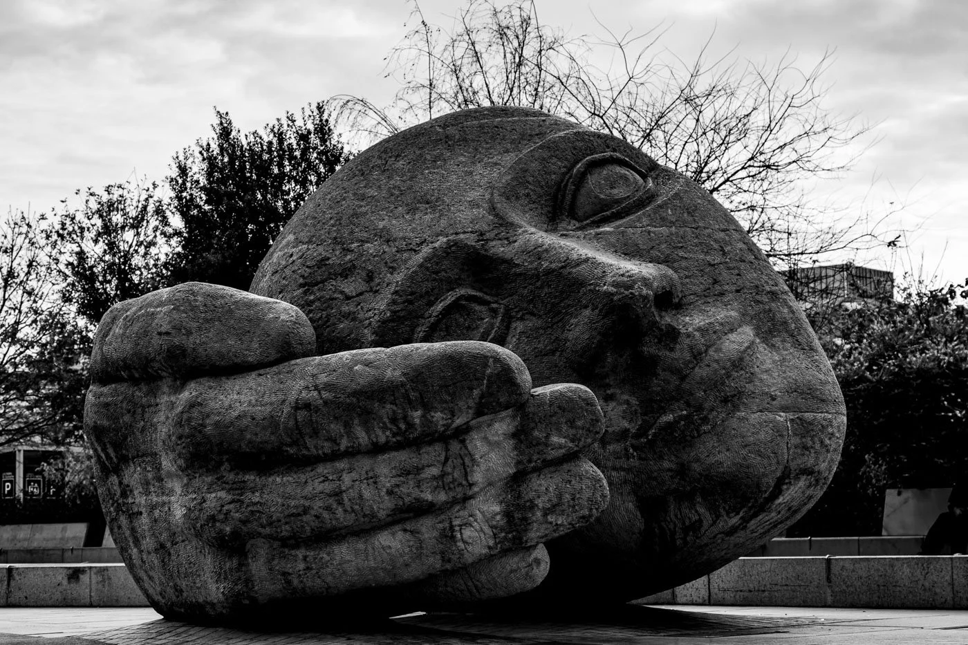 Black and white photograph of L'Écoute (The Listener) sculpture outside the Gare Saint-Charles train station in Marseille, France.