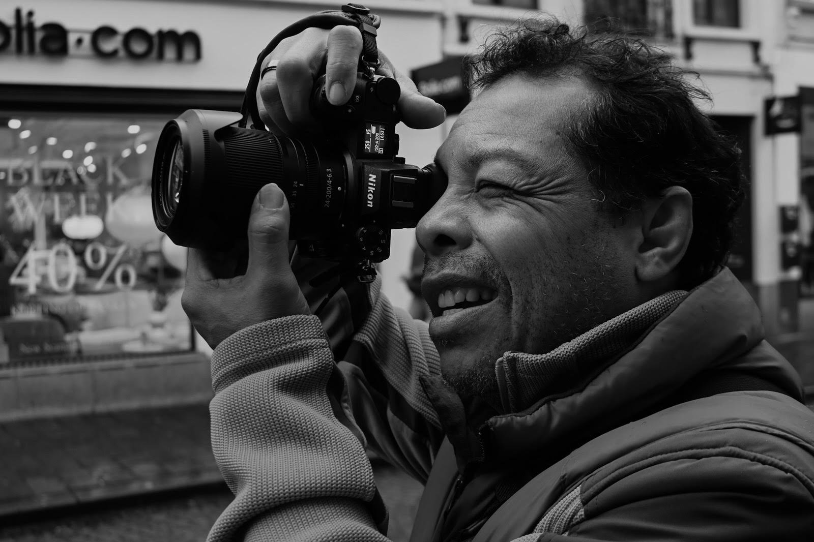 A black and white self-portrait of photographer Alexandro Dos Santos.