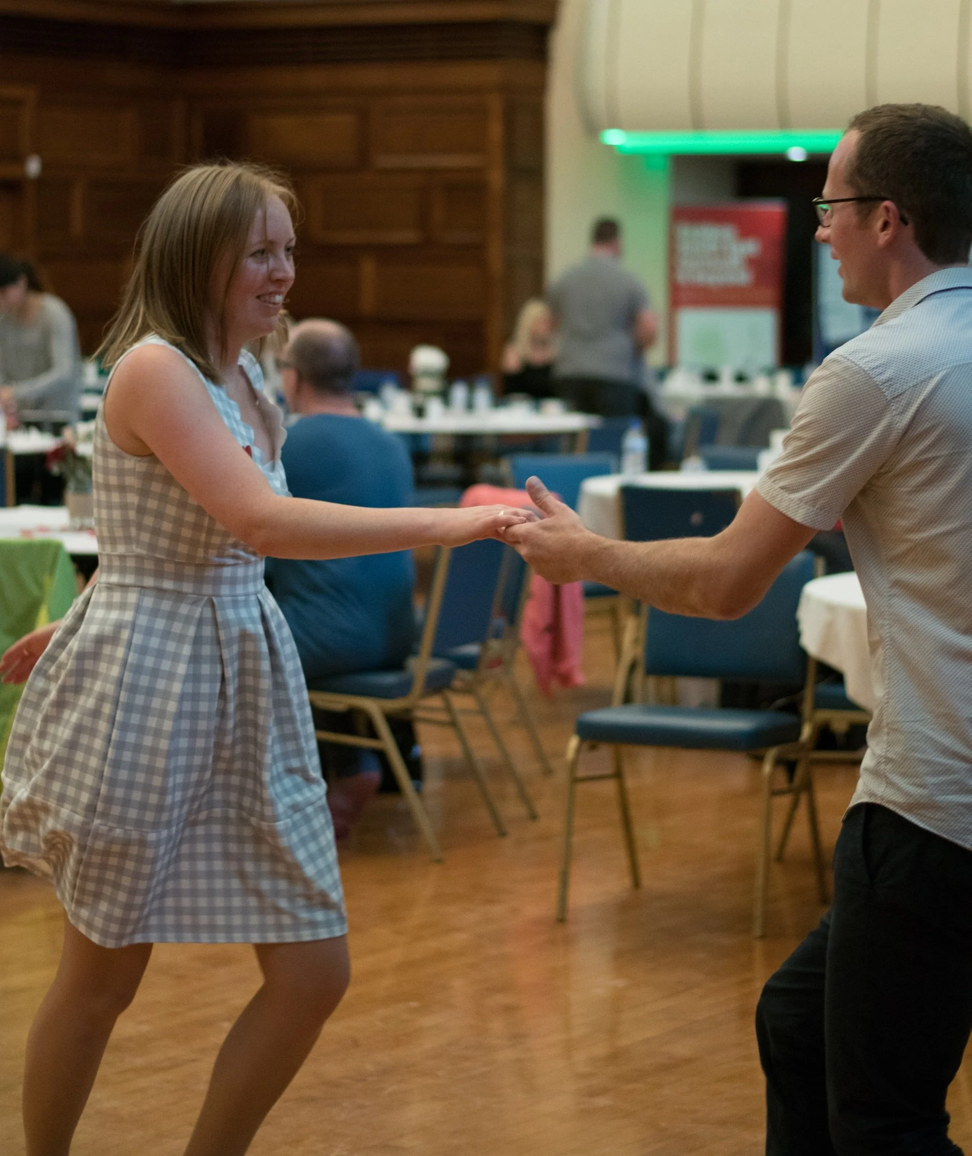 Swing Dancers Amanda and John  holding hands and dancing at a social event