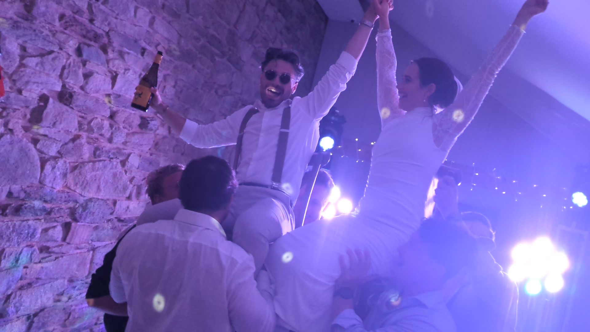 Wedding couple raised on guests’ shoulders during a high-energy evening celebration at Trevenna Barns wedding venue.