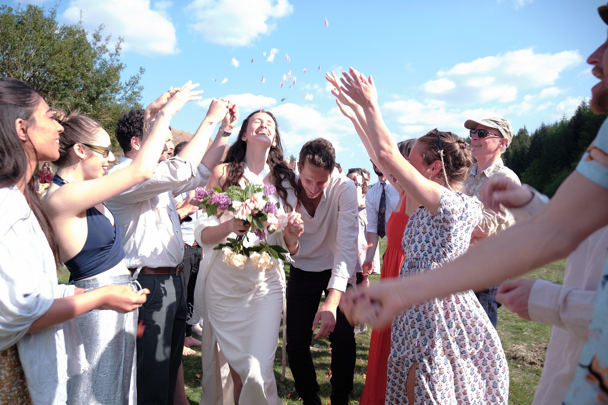 Newlyweds walking through confetti at their outdoor Dartmoor wedding ceremony.