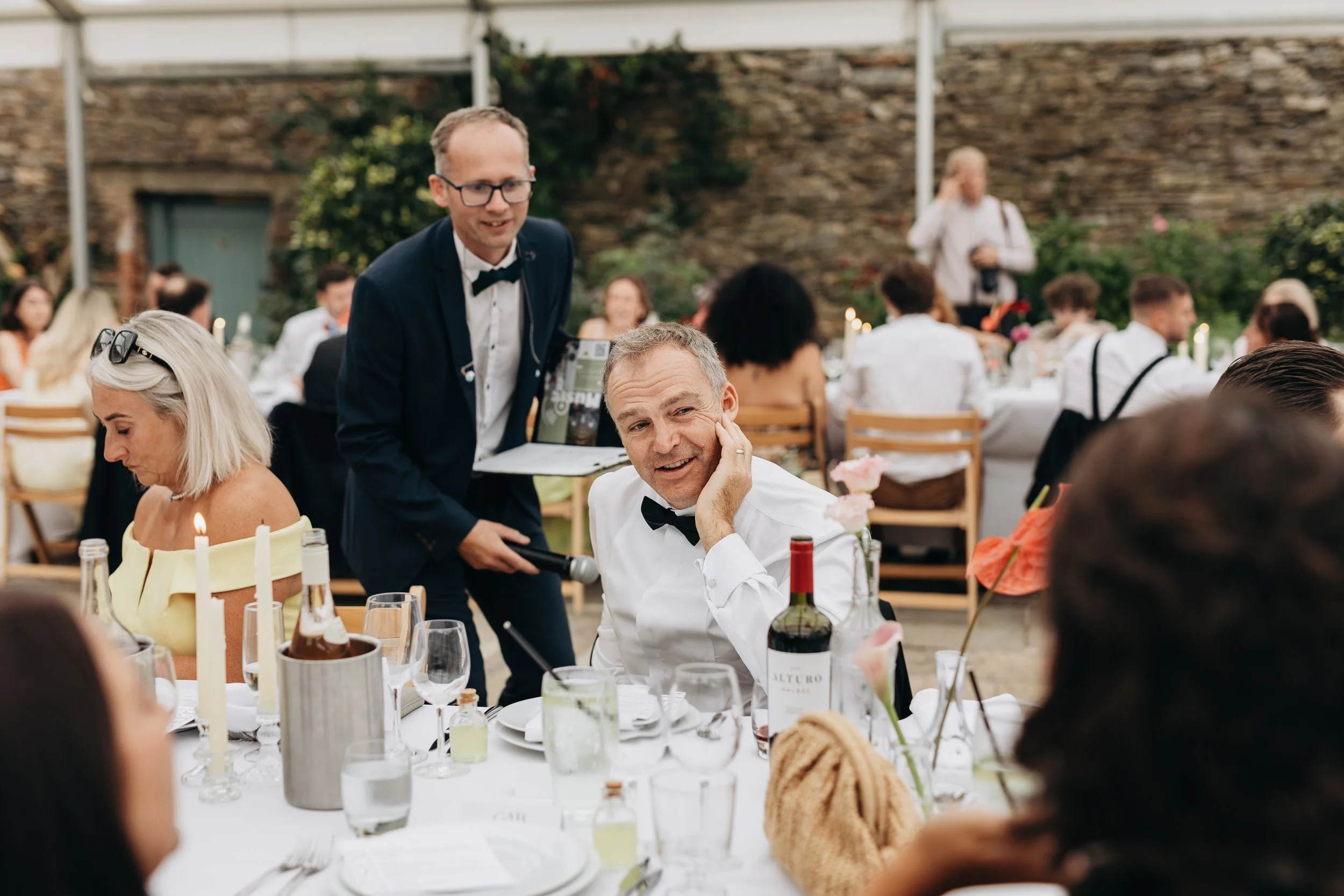 Wedding host John william at Kingston Estate, hosting Wedding reception in Rose Garden, preparing best man for speeches