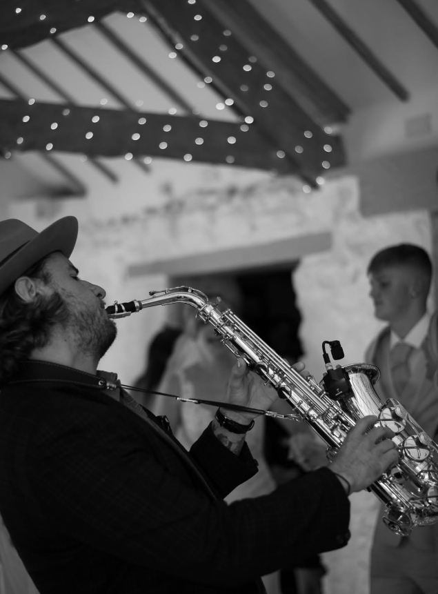 Alex Cairns playing a saxophone with DJ John William at Wonwood Barton, at a very special wedding during first dance set.