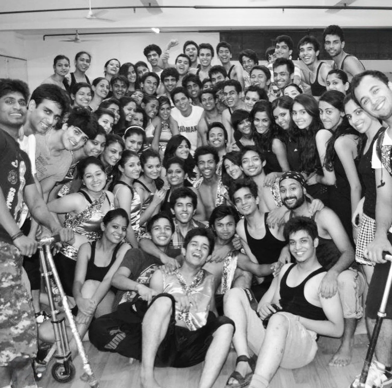A group of young men and women smiling and posing together for a photo in an indoor setting.