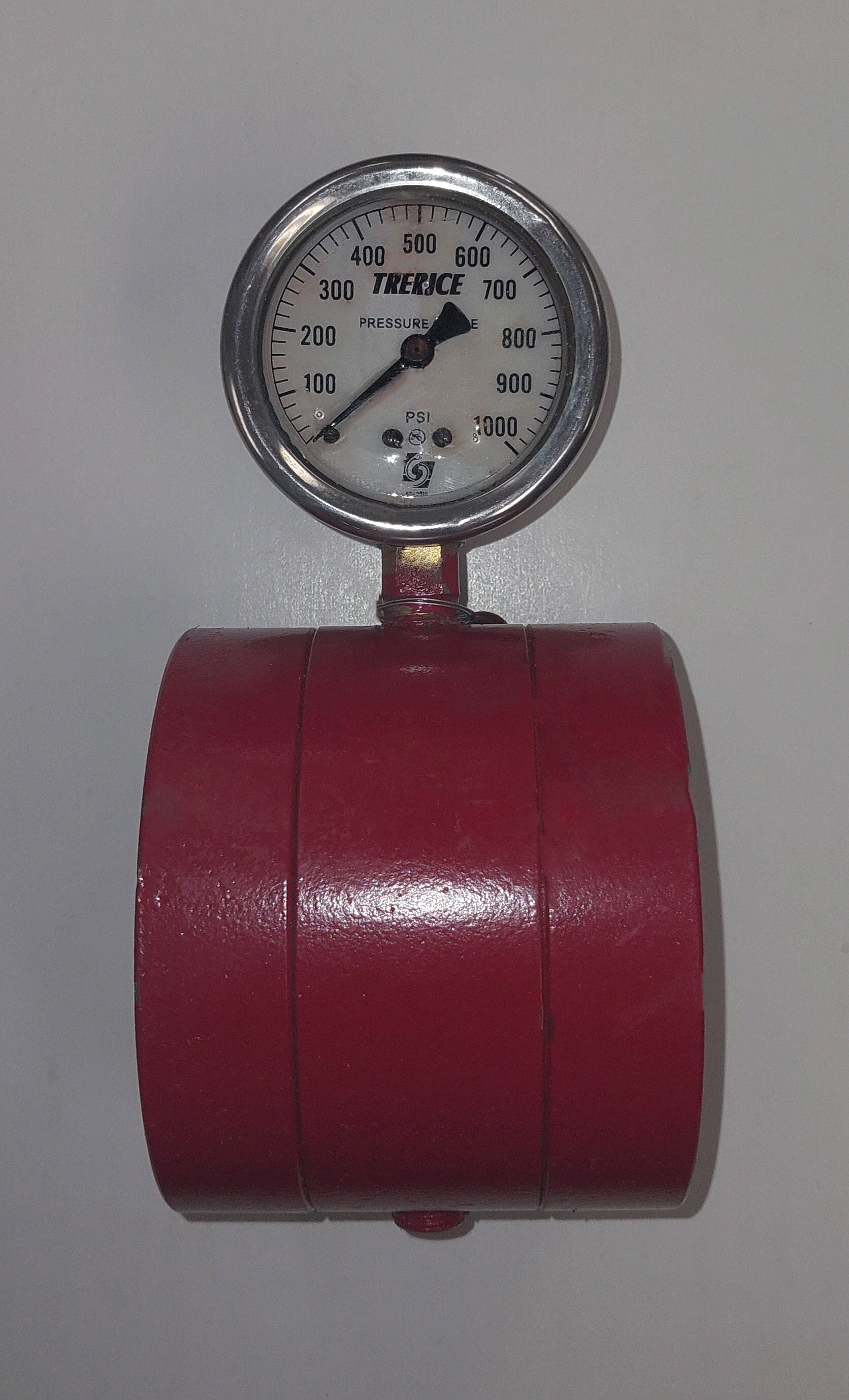 A pressure gauge with a red wheel below it, showing pressure around 240 PSI.