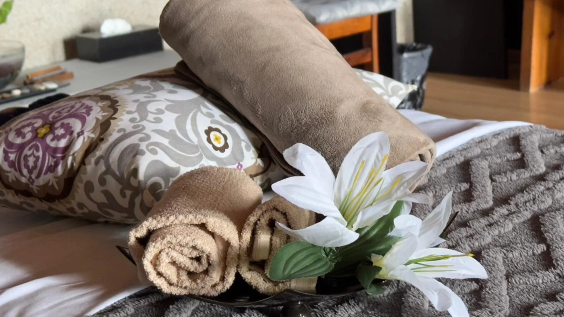 Ramos de toallas y flores blancas decorativas en una cama