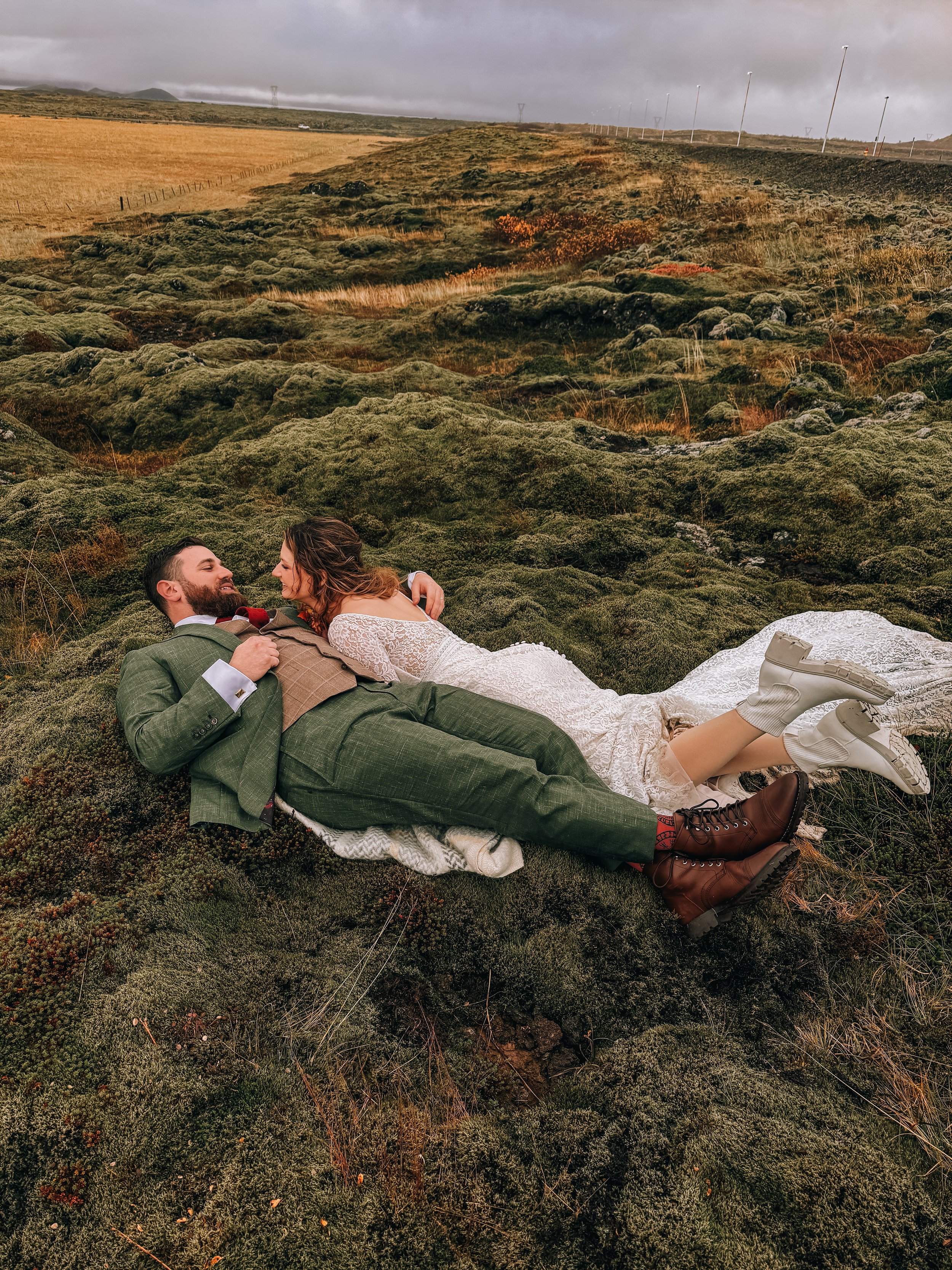Destination wedding in Iceland as bride and groom pose in a scenic location and their content creator captures the moment