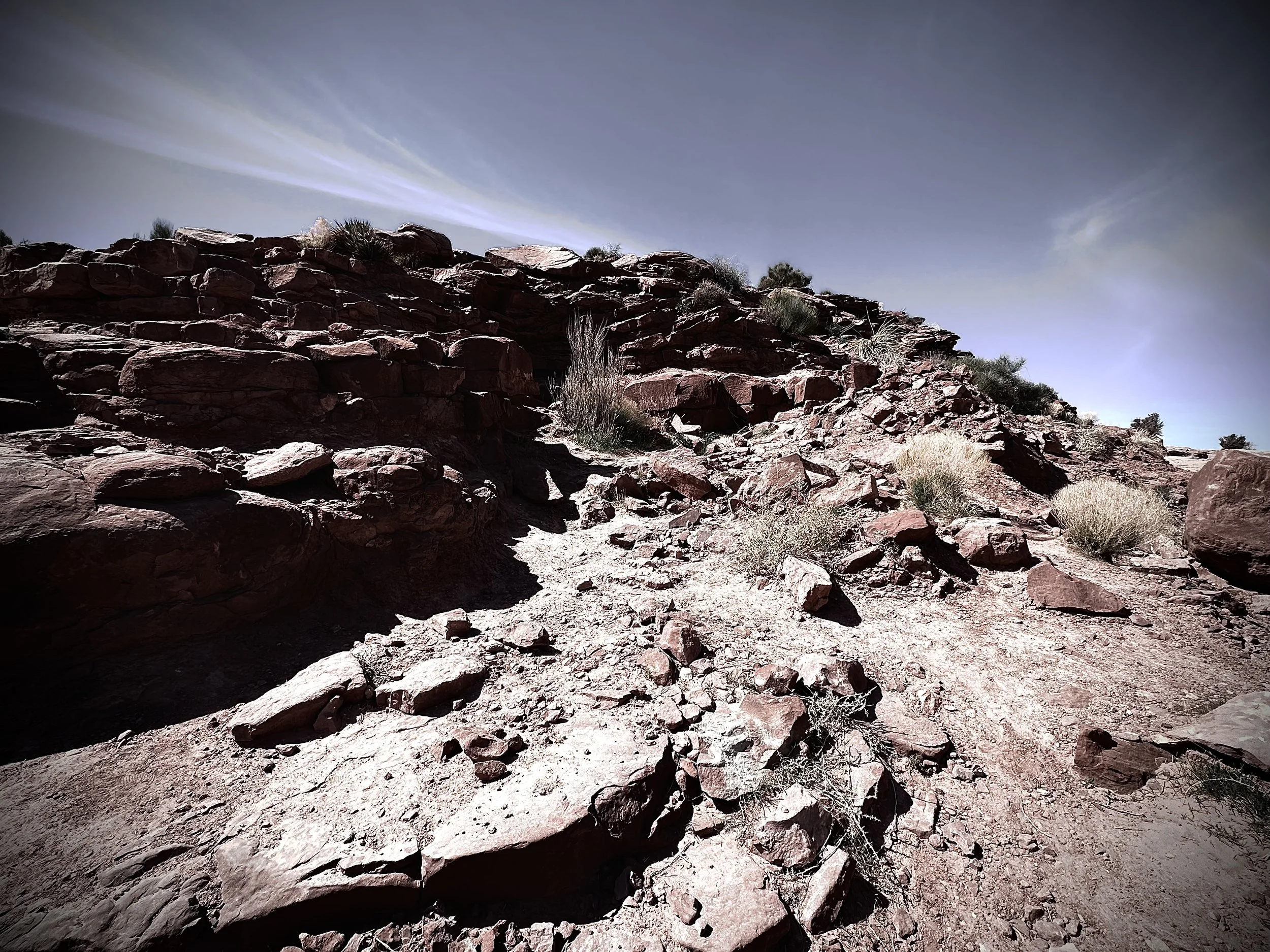 A quarry with a re filter over it. Rocks pile upon rocks with very little vegetation.