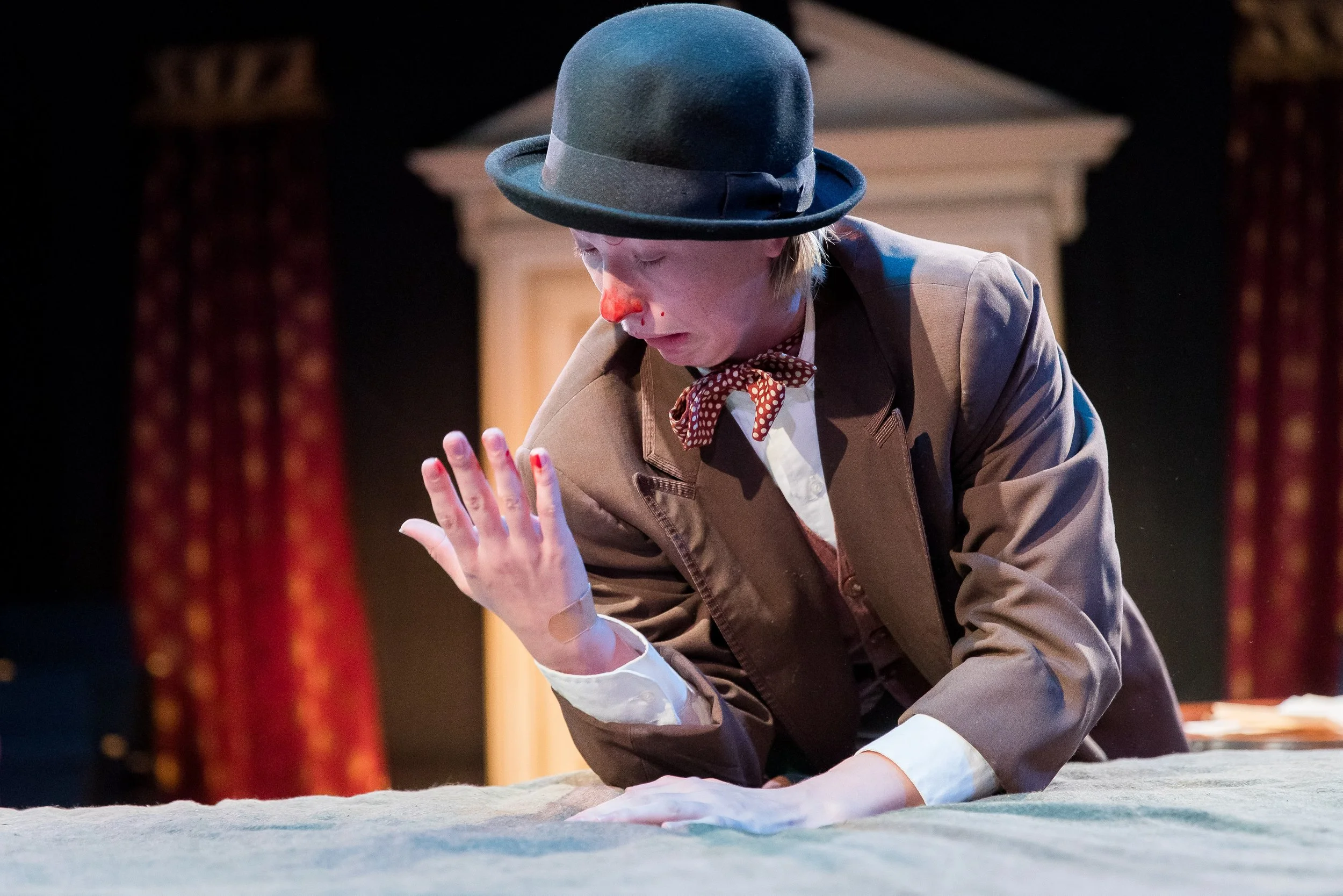 Actor with bloody nose staring looking at hand with incredulous expression