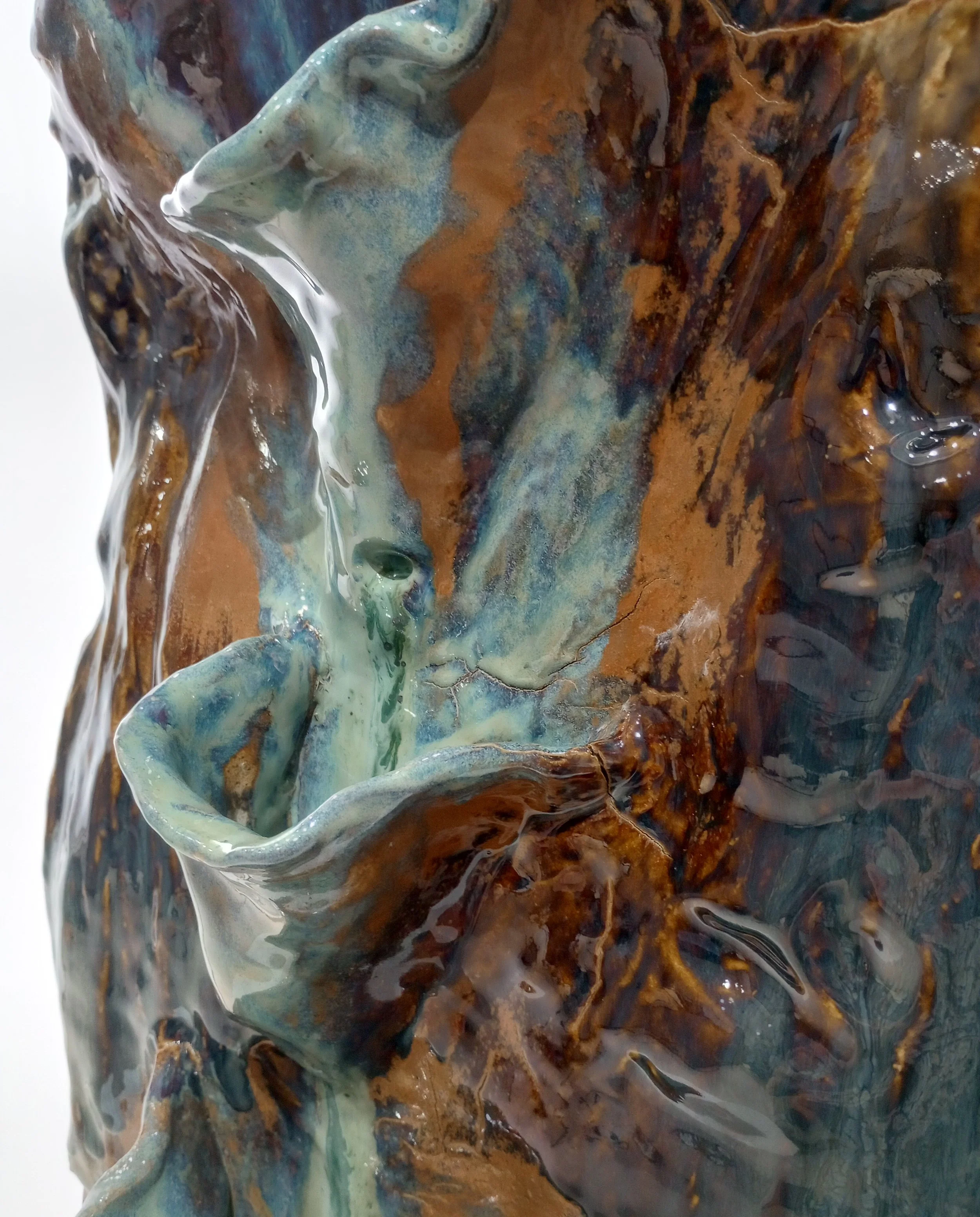 Close up on two small blue pockets on large ceramic sculpture.