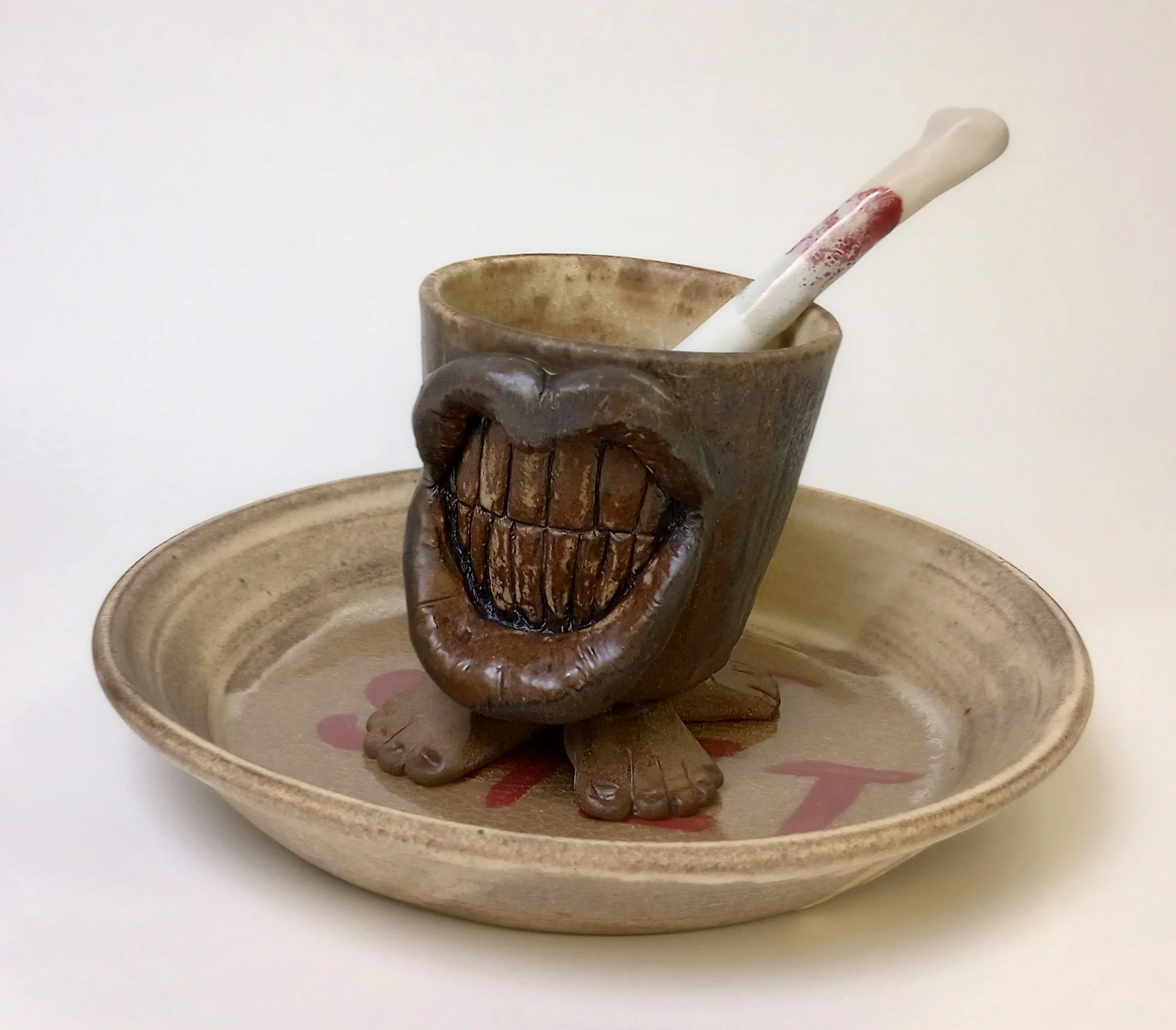 Mug with a large smile sitting on a plate