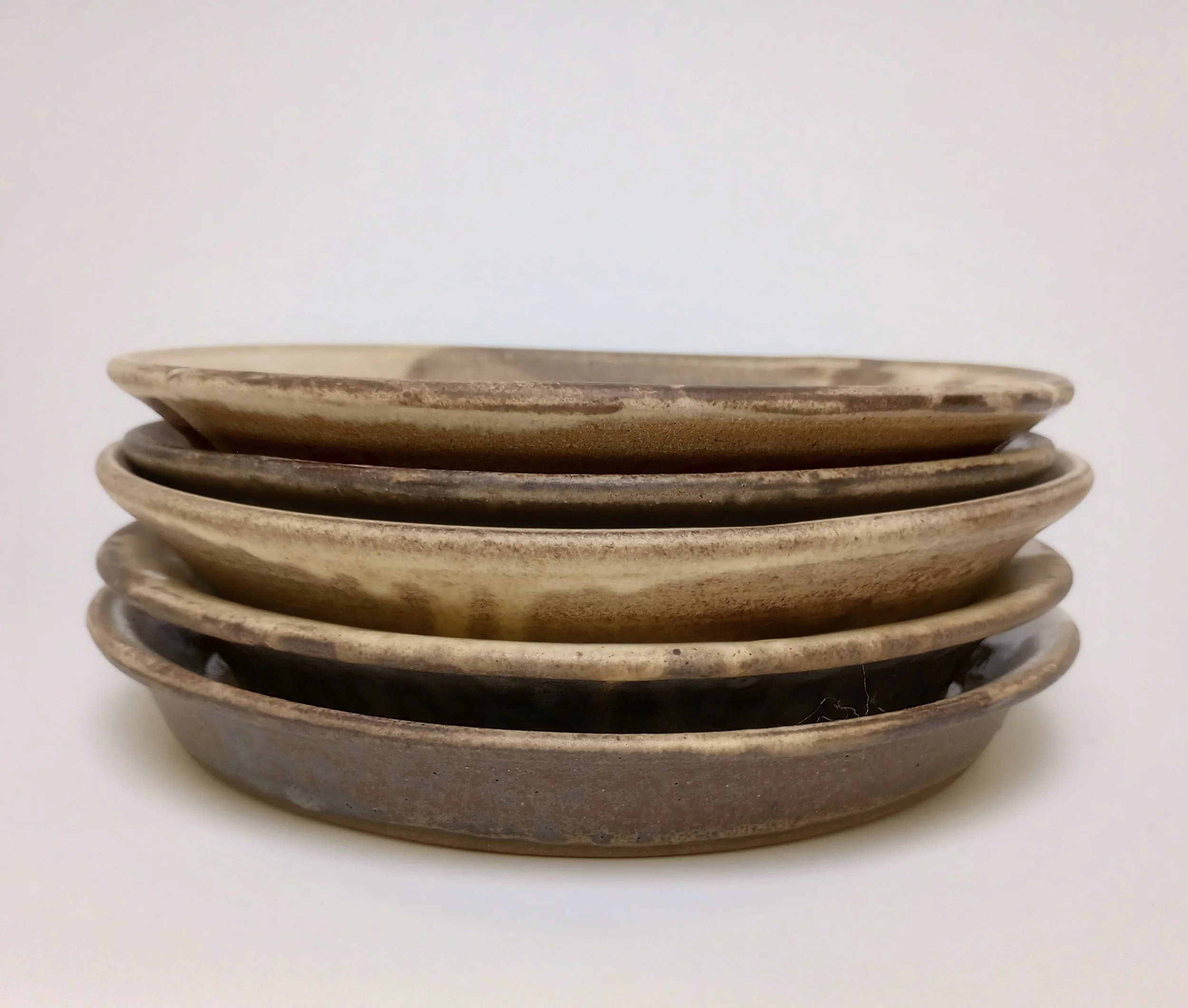 Stack of ceramic plates with yellow and brown glaze.