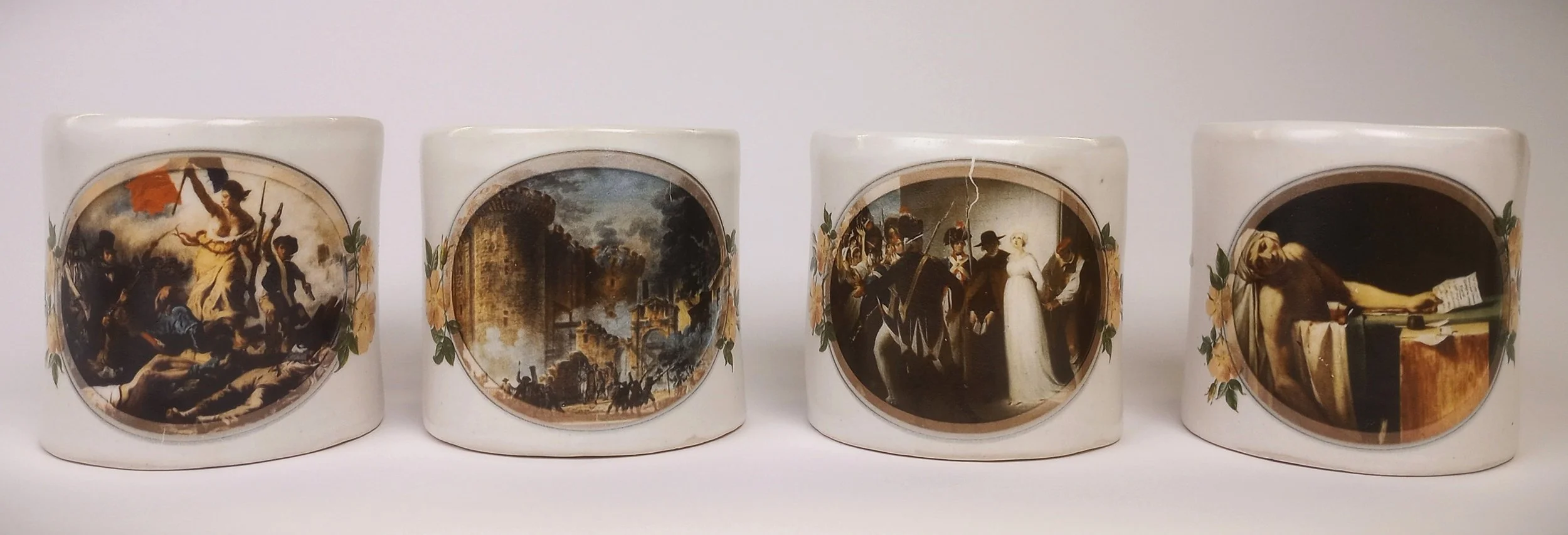 Row of four sturdy coffee mugs with images of paintings on the fronts.