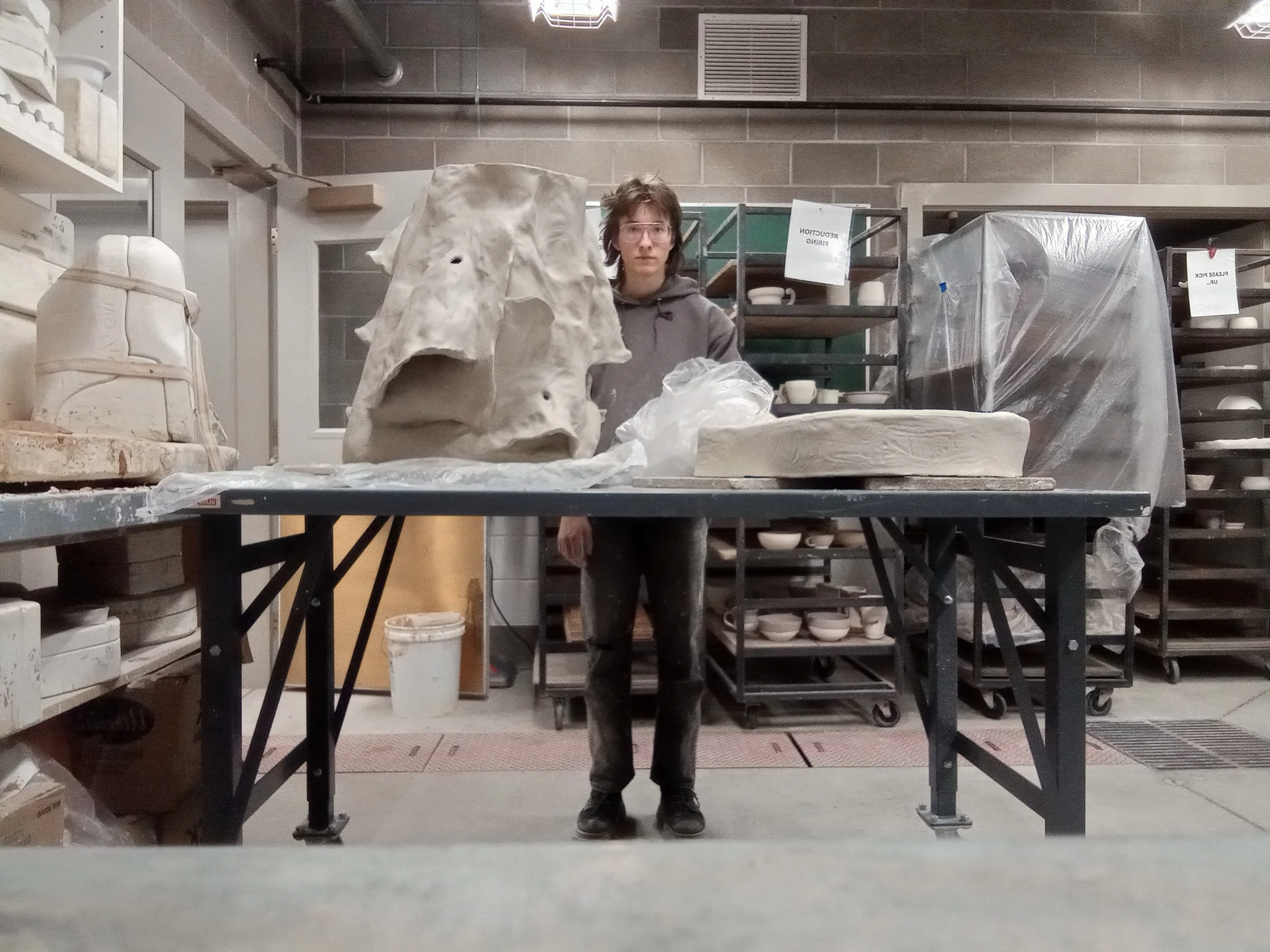 ZEWJ behind a large unfinished ceramic sculpture