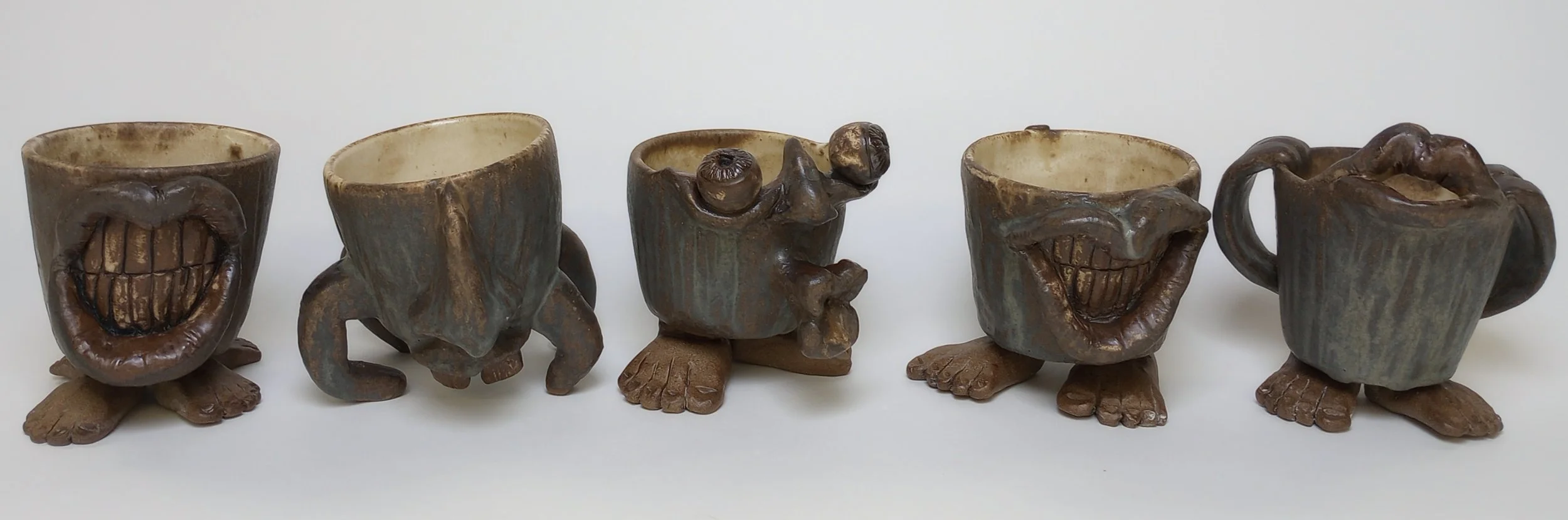 Five mugs with exaggerated facial features