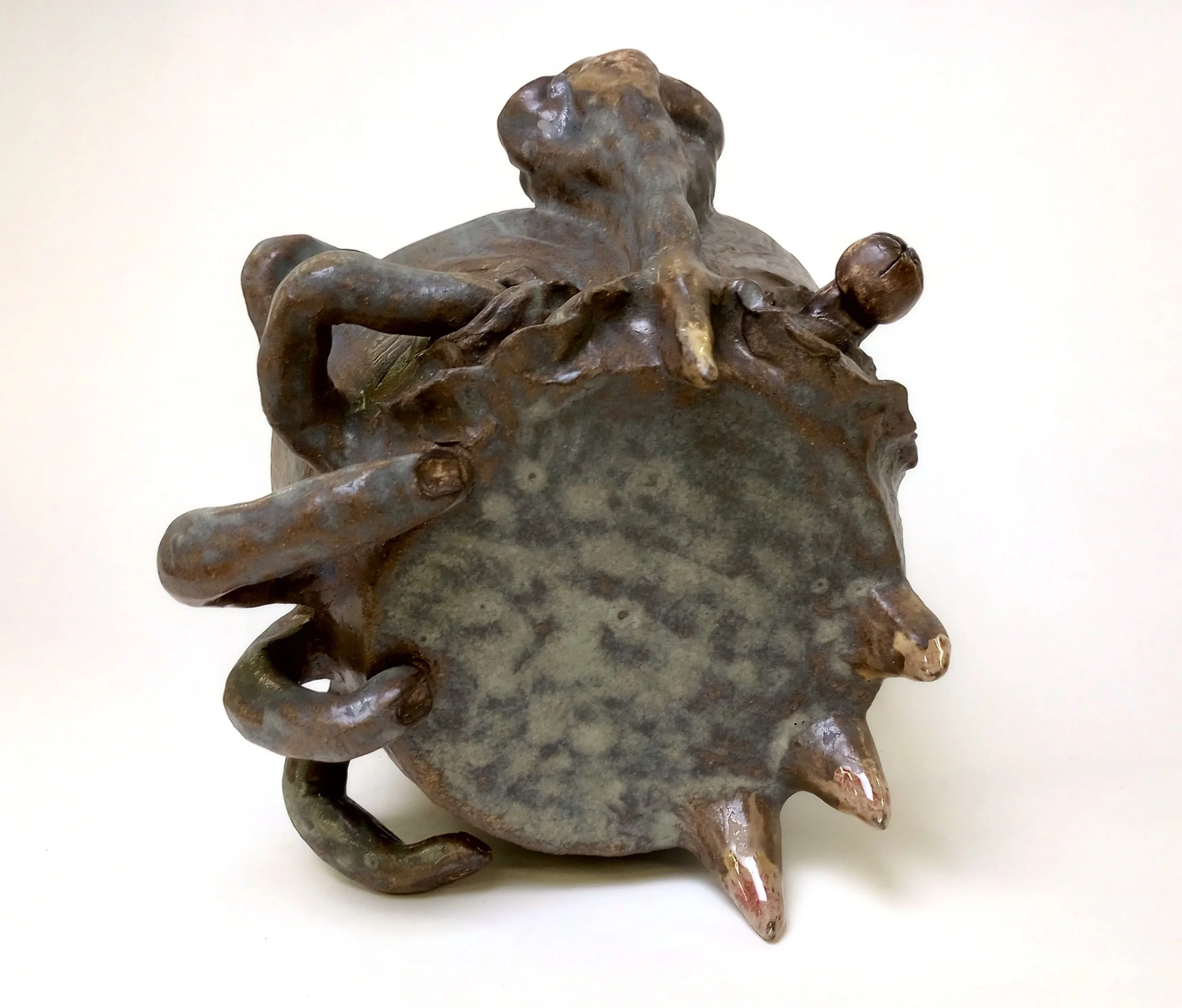 Top view of a ceramic helmet with big nose, fingers, and spikes.