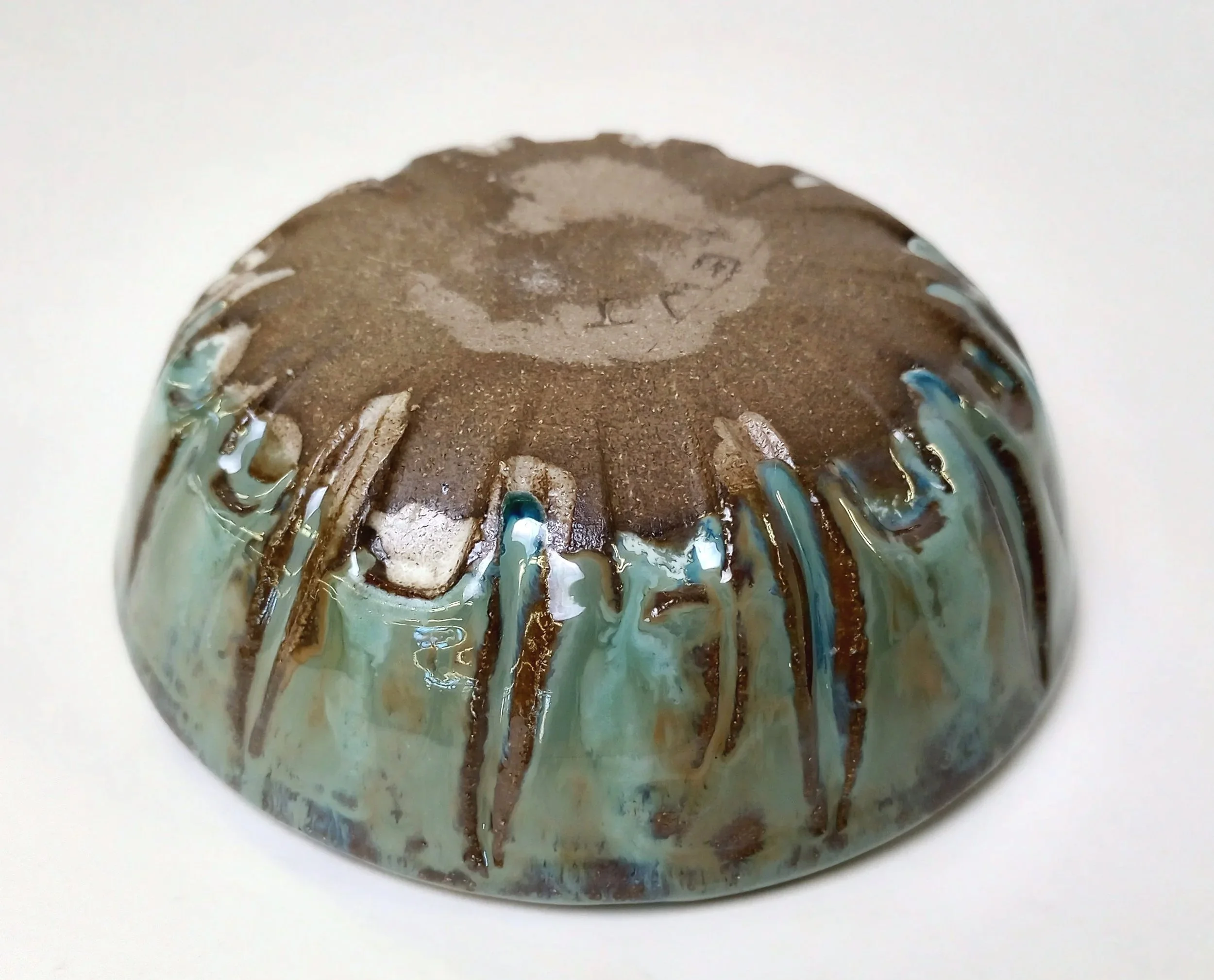 Bottom of a blue bowl with carved decorations