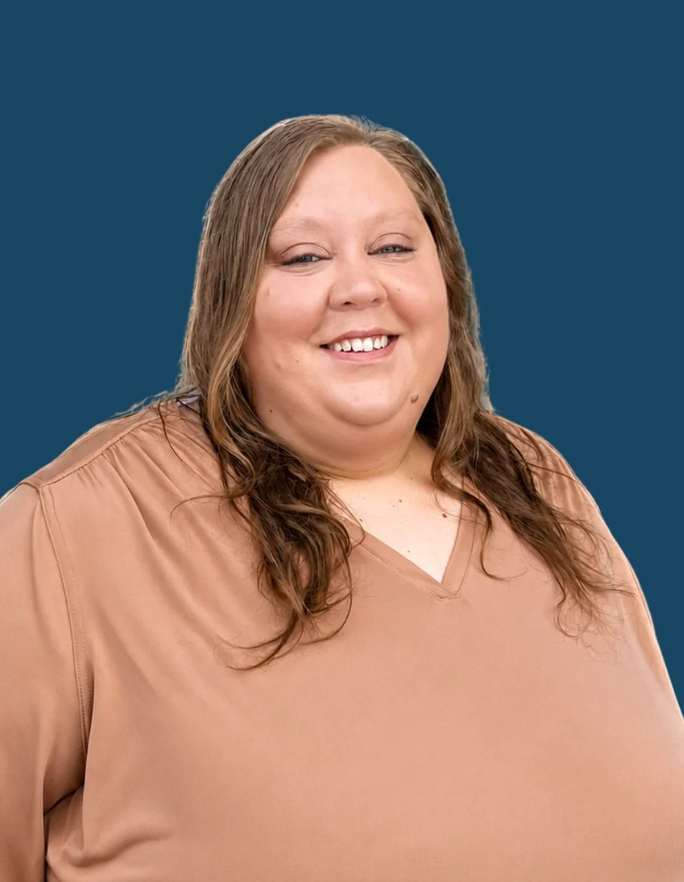 Portrait of Angelica Conley, Food Service Supervisor, smiling and wearing a beige blouse, posed against a dark blue circular background