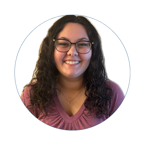 A portrait of a woman with blonde curly hair, wearing a black top, smiling against a white background. Vicki Minor, Director of Business Development 