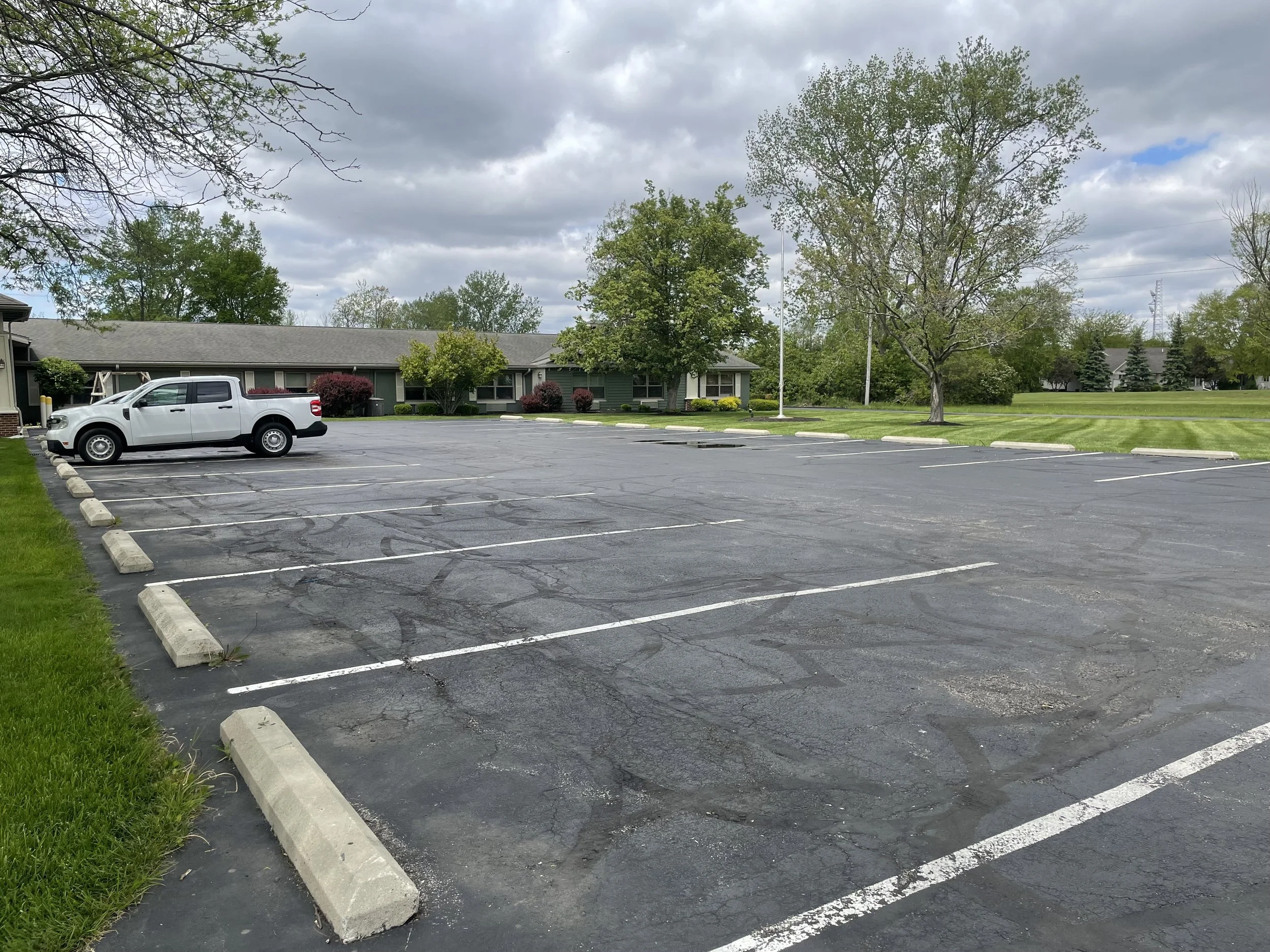 Spacious and accessible parking lot at Fieldstone Nursing and Rehabilitation Center surrounded by lush greenery for convenient visitor and family access.