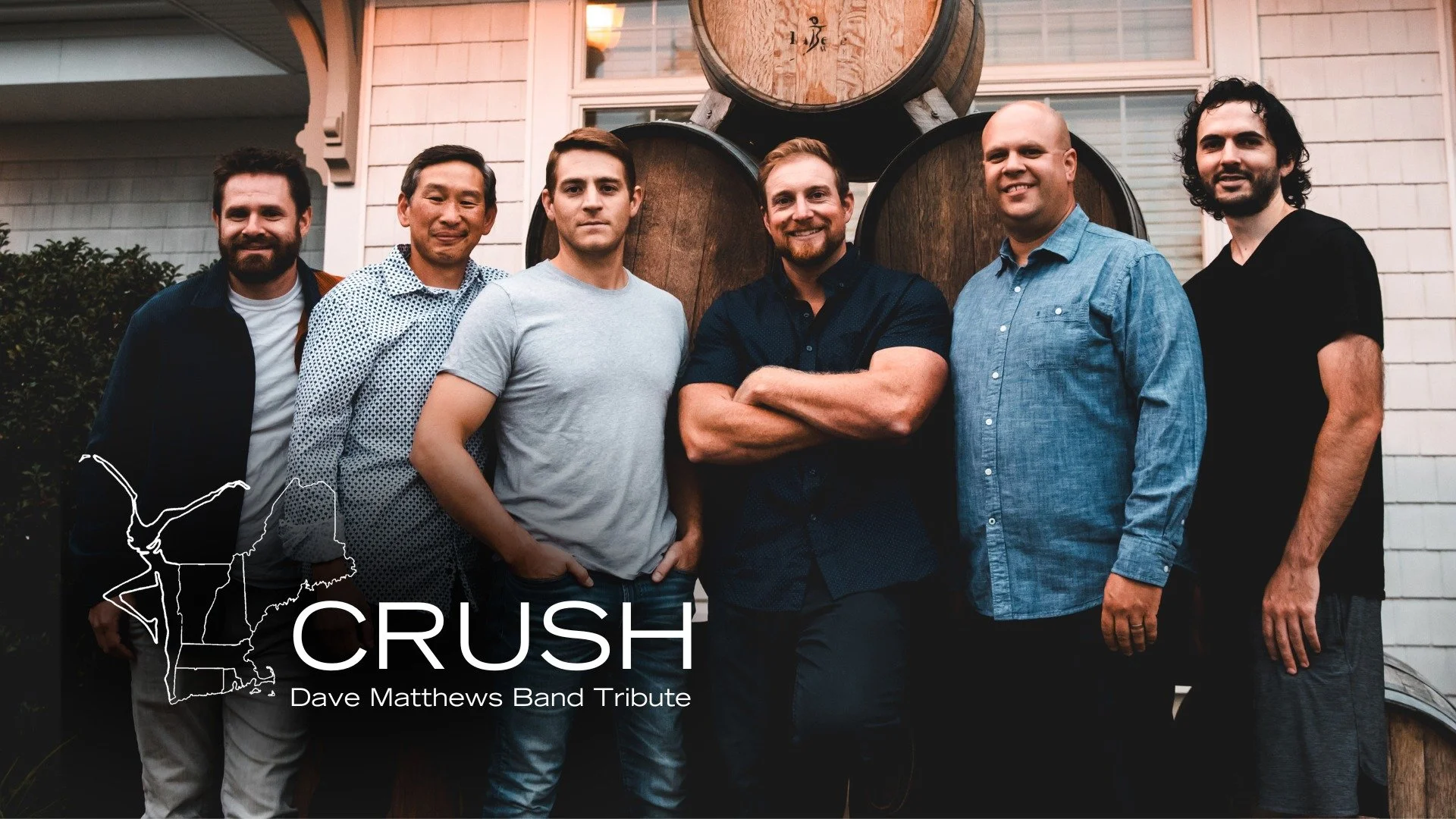 Group photo of six men standing in front of a building and a large wooden barrel, with a map outline and the text 'CRUSH Dave Matthews Band Tribute' in the lower left corner.