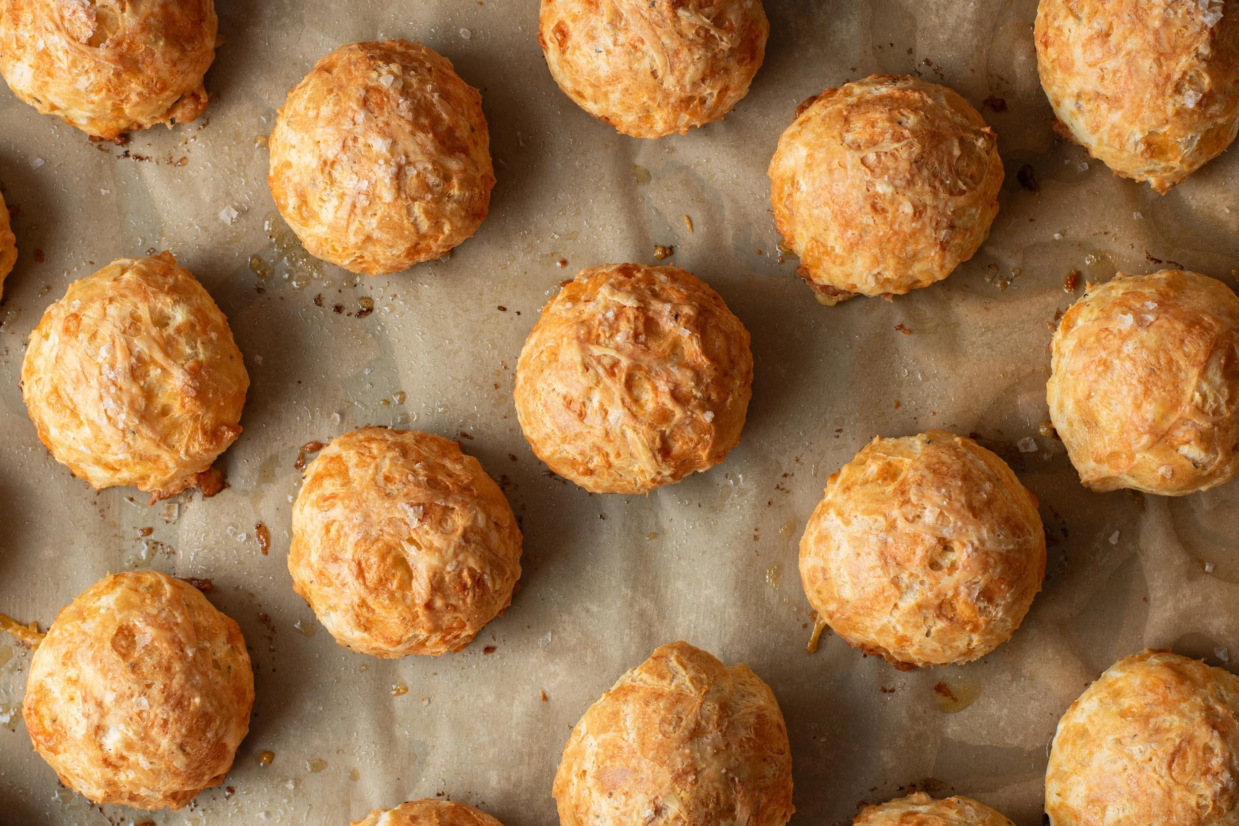 Baked cheese balls on parchment paper.