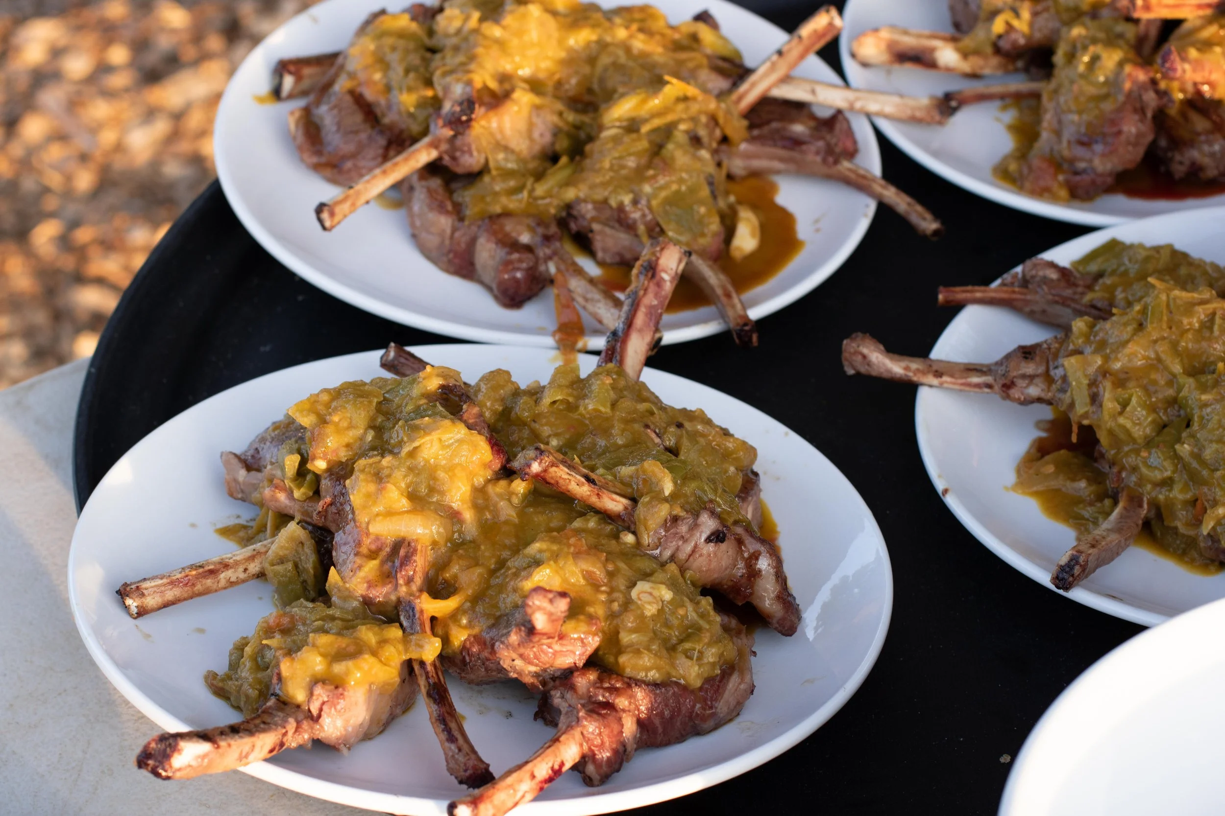 Plate of grilled lamb chops topped with green chili sauce