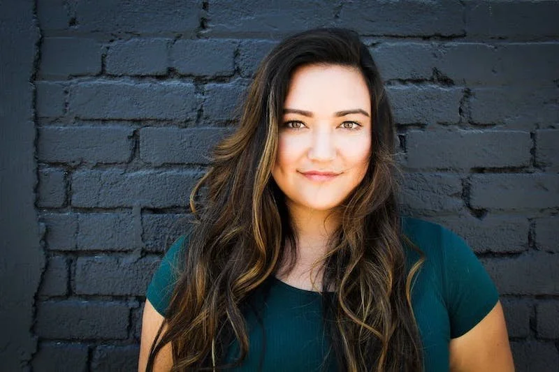 A woman looking ahead in a teal shirt