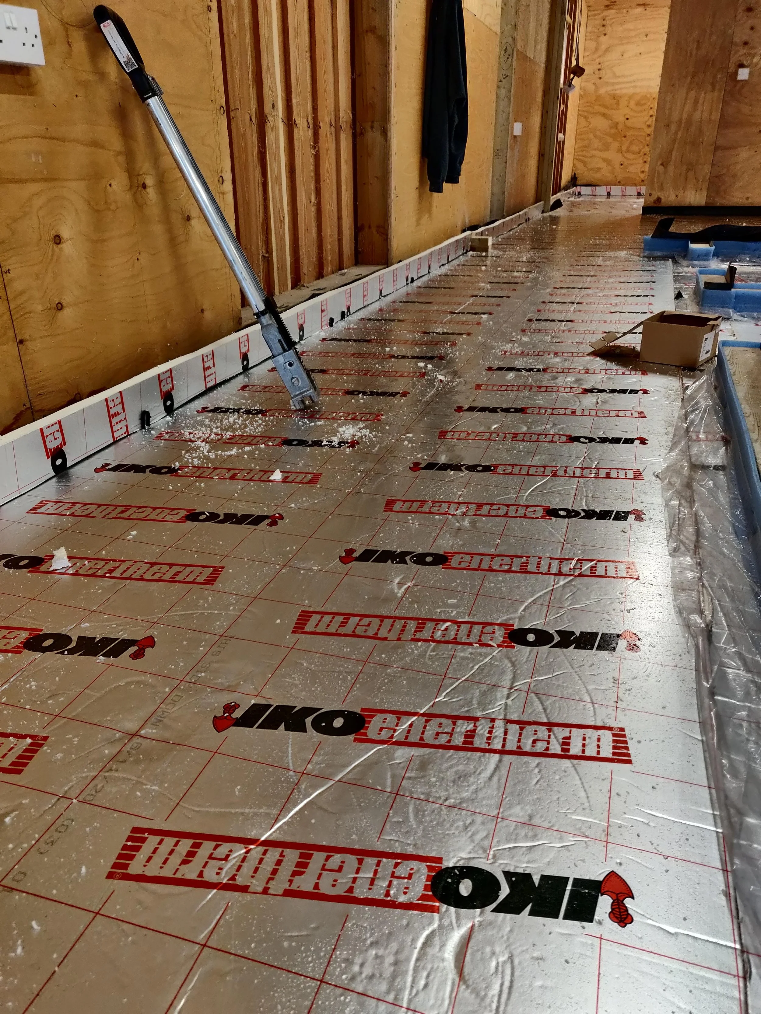 Construction site showing a floor being prepared for liquid screed flooring with PIR insulation with a construction laser level pointed towards the floor in West Midlands.