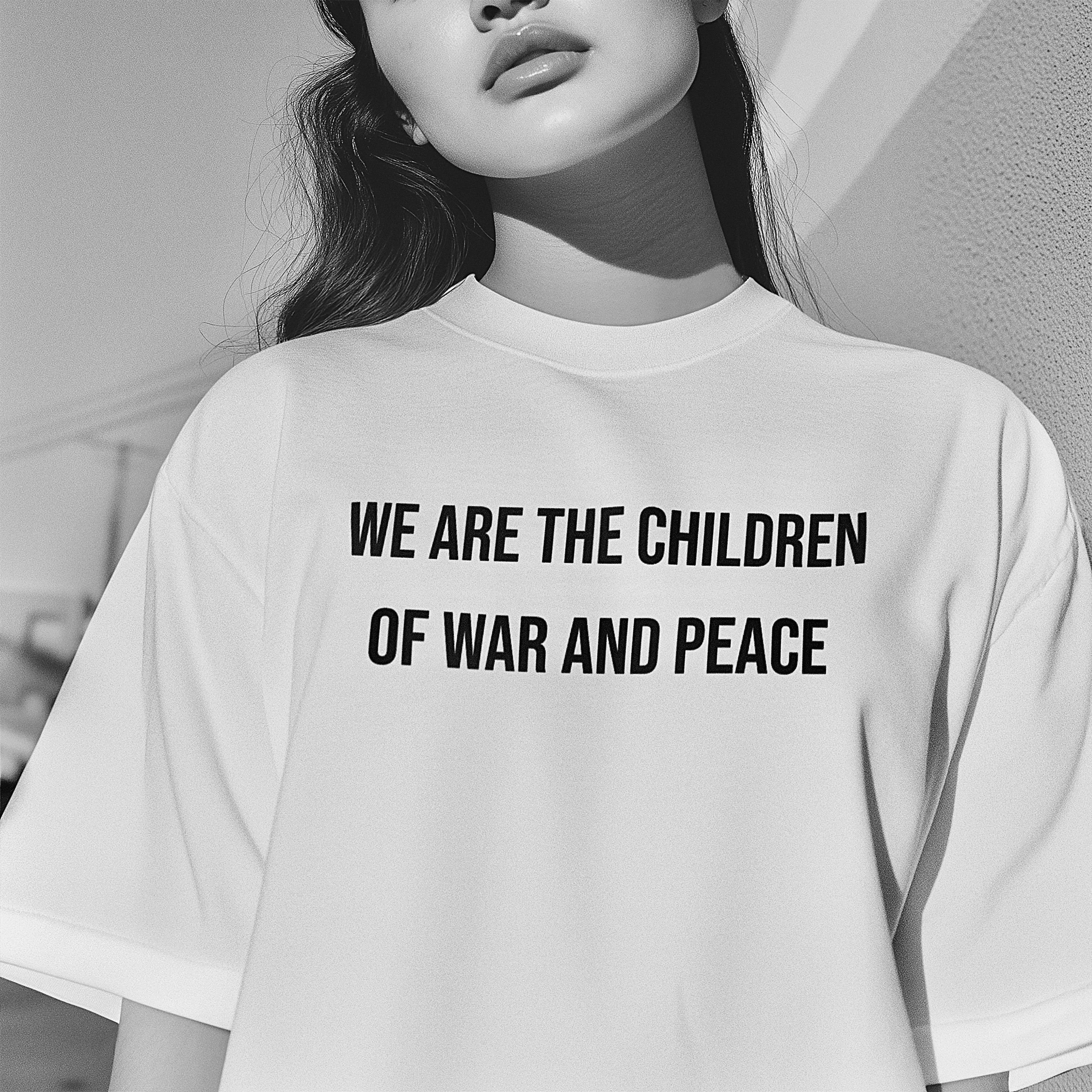 Black and white image of a woman wearing a T-shirt with the text 'We are the children of war and peace' printed on it.
