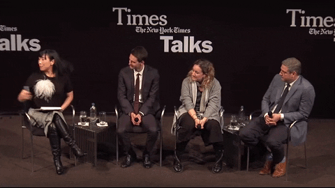 Four people seated on a stage with a black background displaying 'Times Talks' and 'The New York Times' logos, engaged in a panel discussion.
