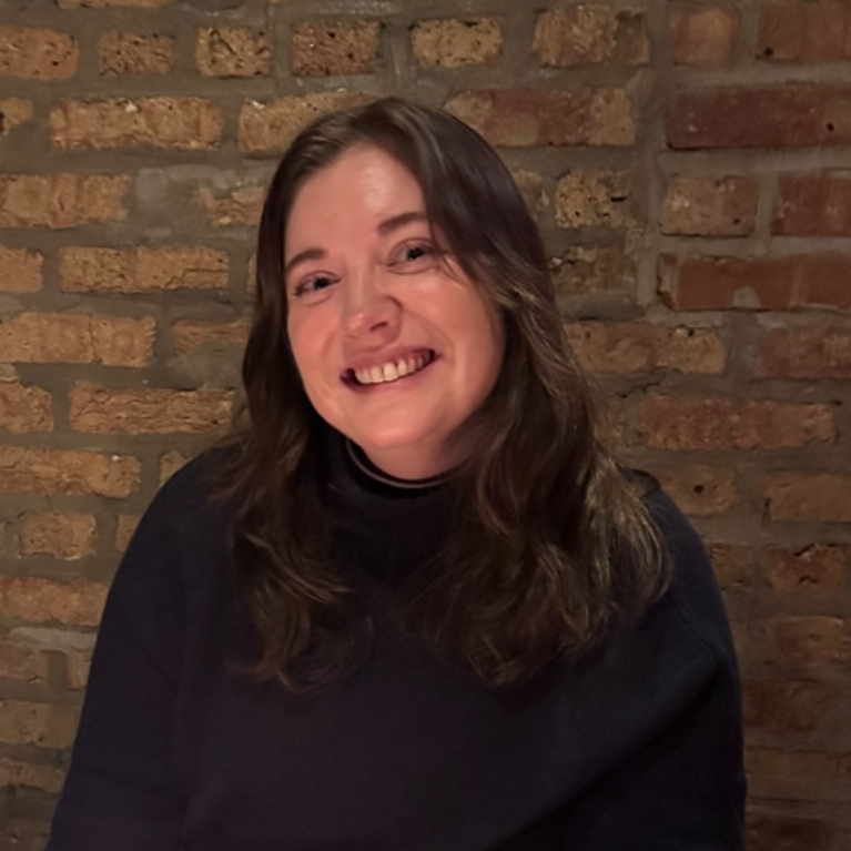 Emily A. Gregor smiling in front of a brick background
