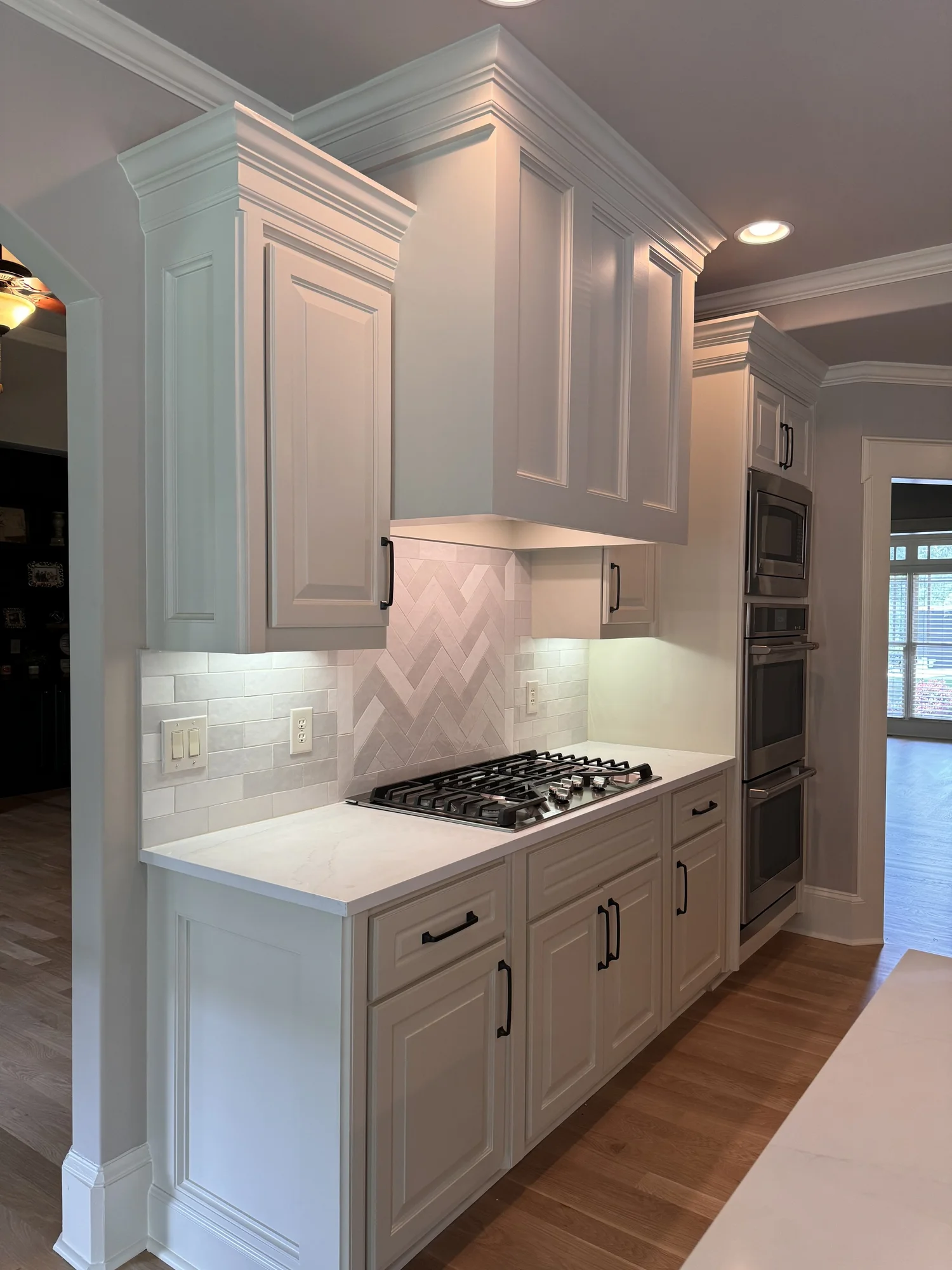 White kitchen hood and herringbone backsplash