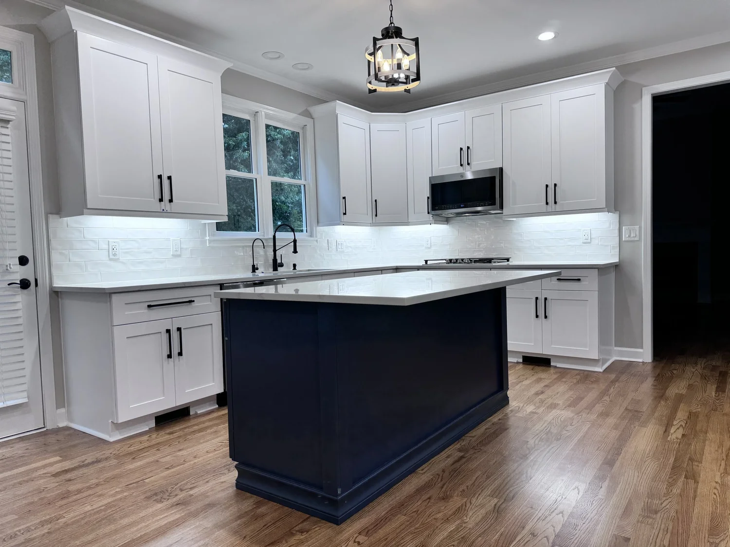 White shaker kitchen with navy island and black hardware